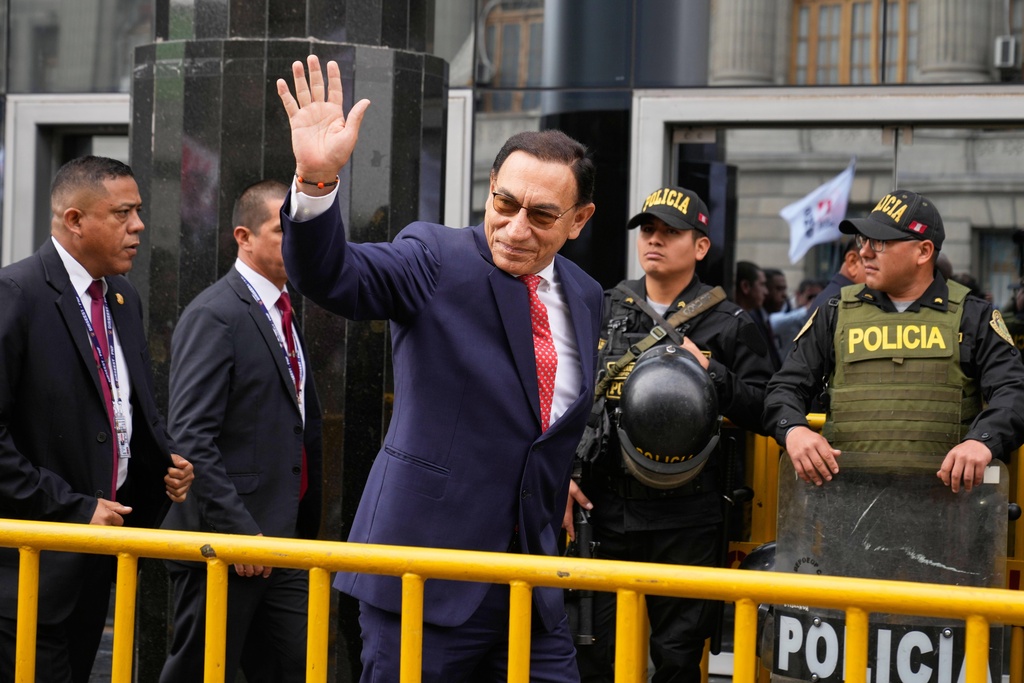 Martin Vizcarra waves as he arrives at a courthouse
