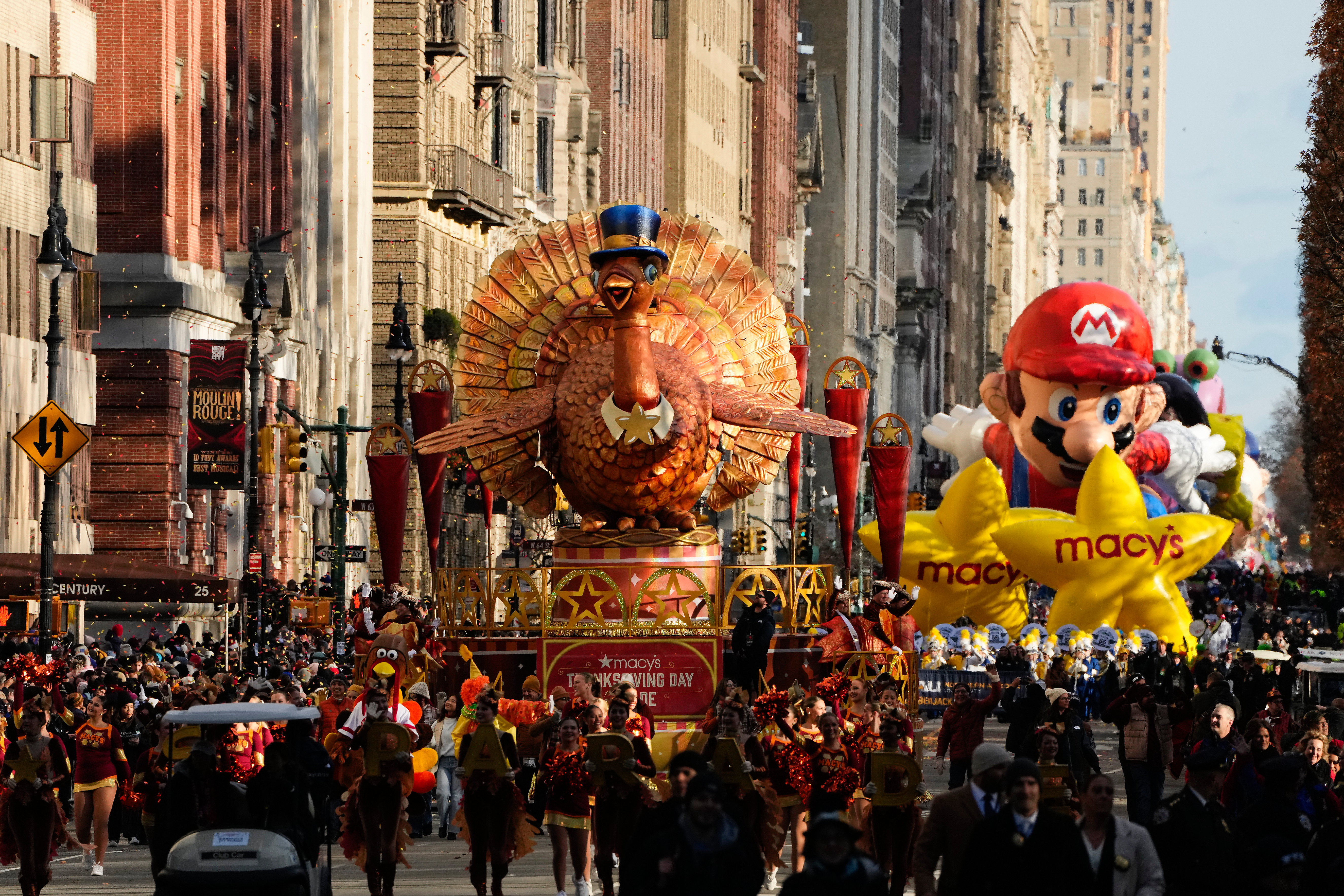 Floats showing a giant turkey and Super Mario Bros travel down Central Park West