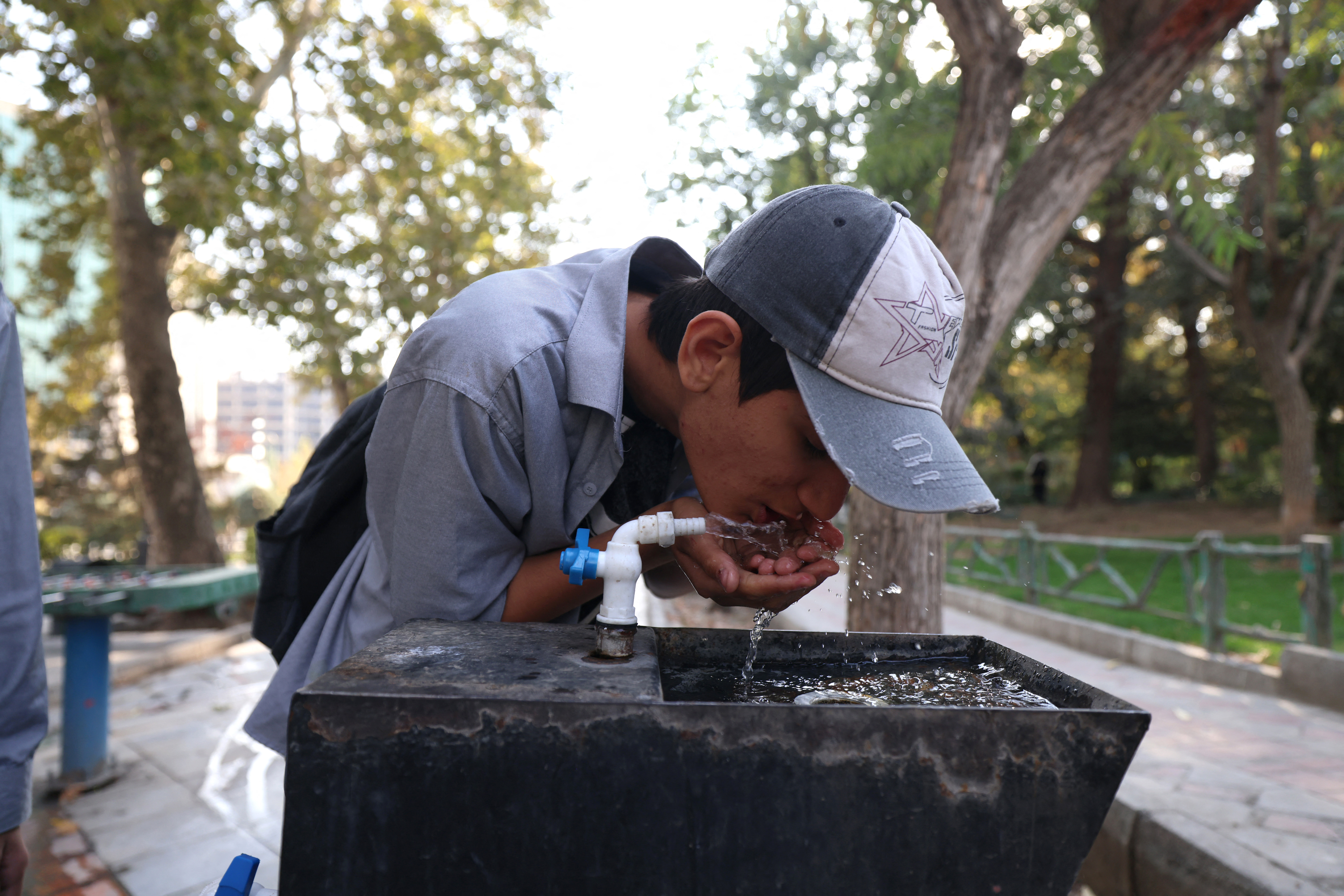A youth drinks water from a fountain in Mellat Park, as the Iran faces sever water shortages, in Tehran on November 9, 2025.
