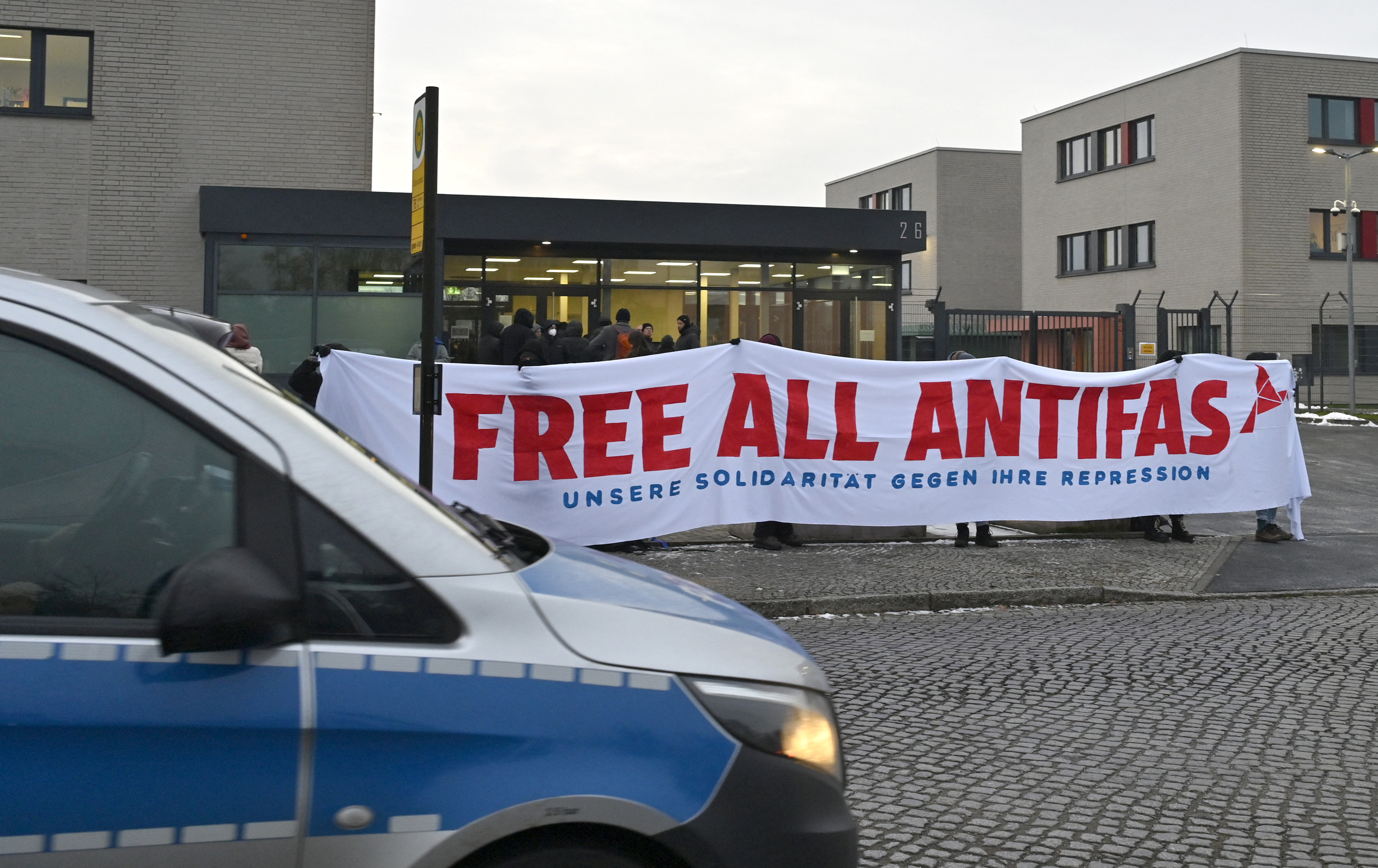 Demonstrators protest prior to the start of a trial of seven accused left extremists for membership in a criminal organisation on November 25, 2025 at the Higher Regional Court of Dresden, eastern Germany.