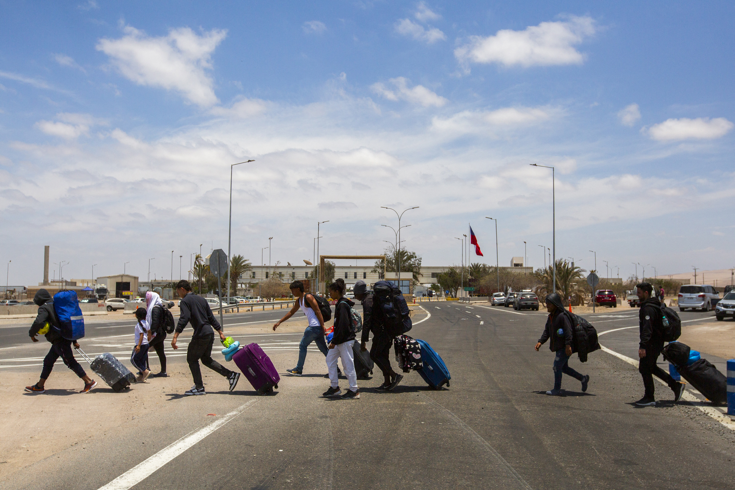 Migrants walk near the Cachalluta border crossing with Peru, about 25 km north of Arica, Chile, on November 28, 2025.