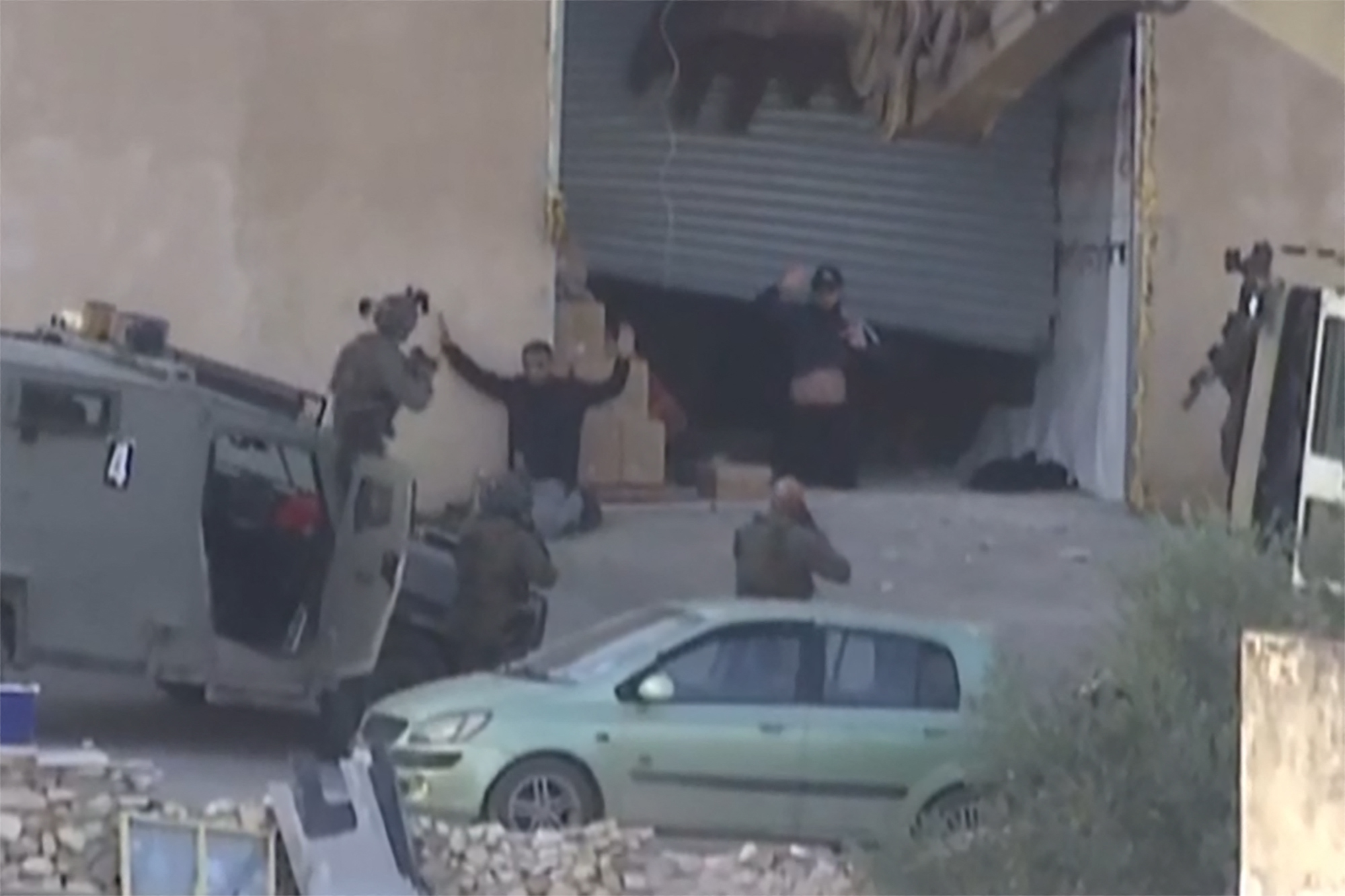 This image grab obtained from Palestine TV footage on November 28, 2025, and filmed a day earlier, shows two Palestinian men raising their hands in apparent surrender before Israeli forces, moments before being seemingly shot by soldiers during a military operation in the Israeli-occupied West Bank city of Jenin.
