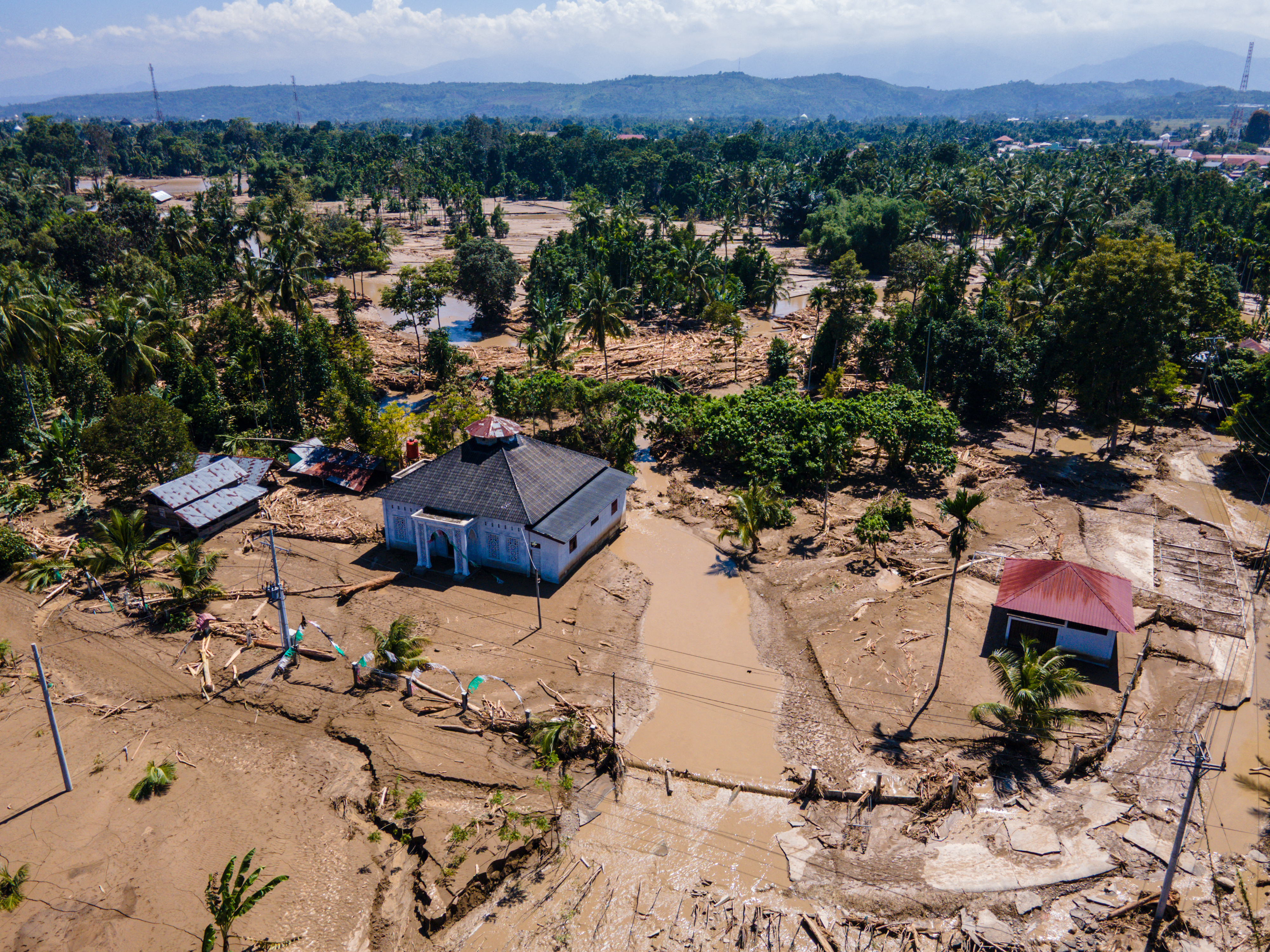 This aerial picture shows a mosque standing amid mud in a flood affected area amid flash floods in Meureudu, Pidie Jaya district Indonesia's Aceh province on November 30, 2025.