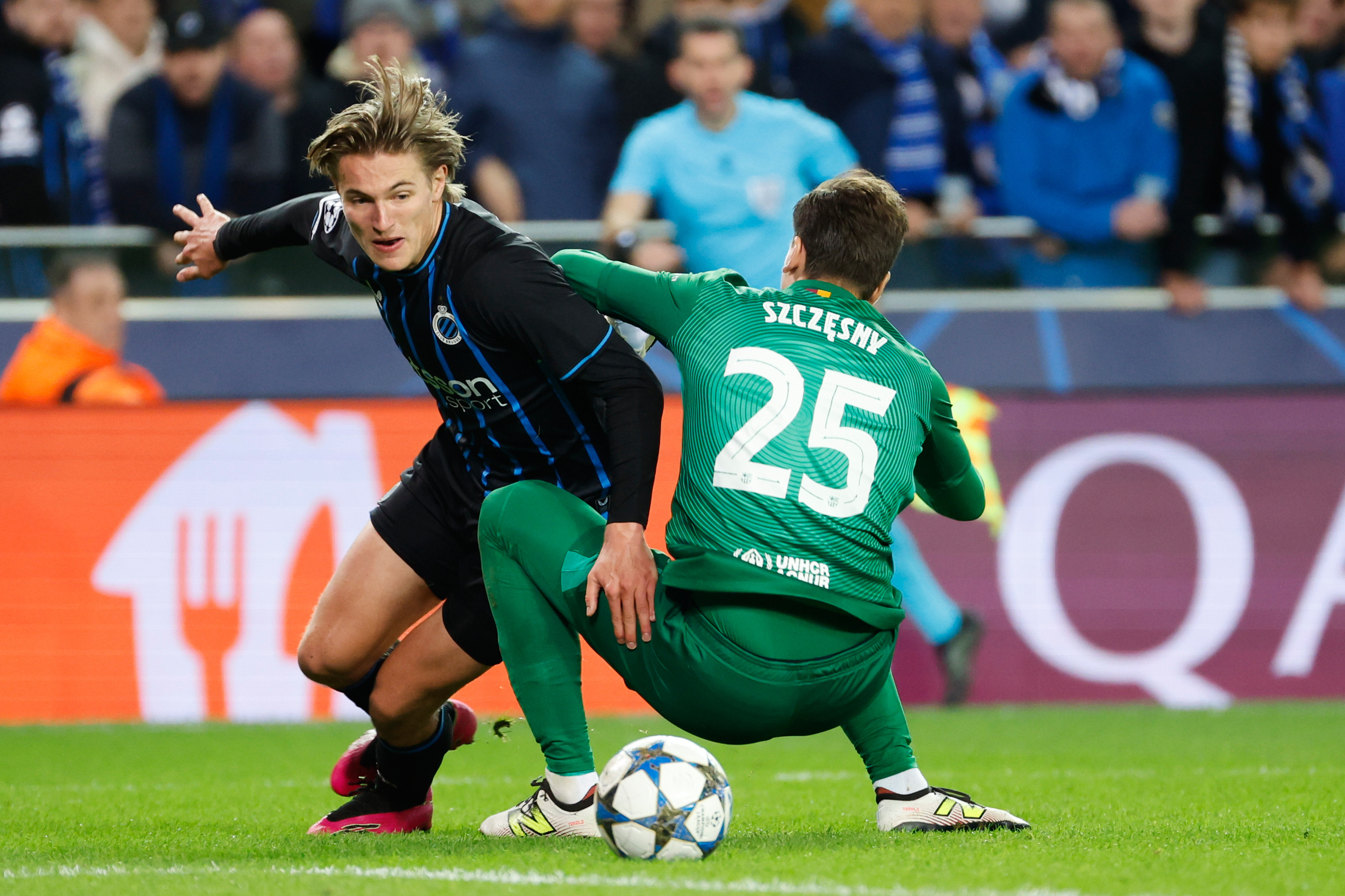 Brugge's Romeo Vermant, left, and Barcelona's goalkeeper Wojciech Szczesny tussle for the ball during the Champions League opening phase soccer match between Club Brugge and Barcelona in Bruges, Belgium, Wednesday, Nov. 5, 2025. (AP Photo/Geert Vanden Wijngaert)