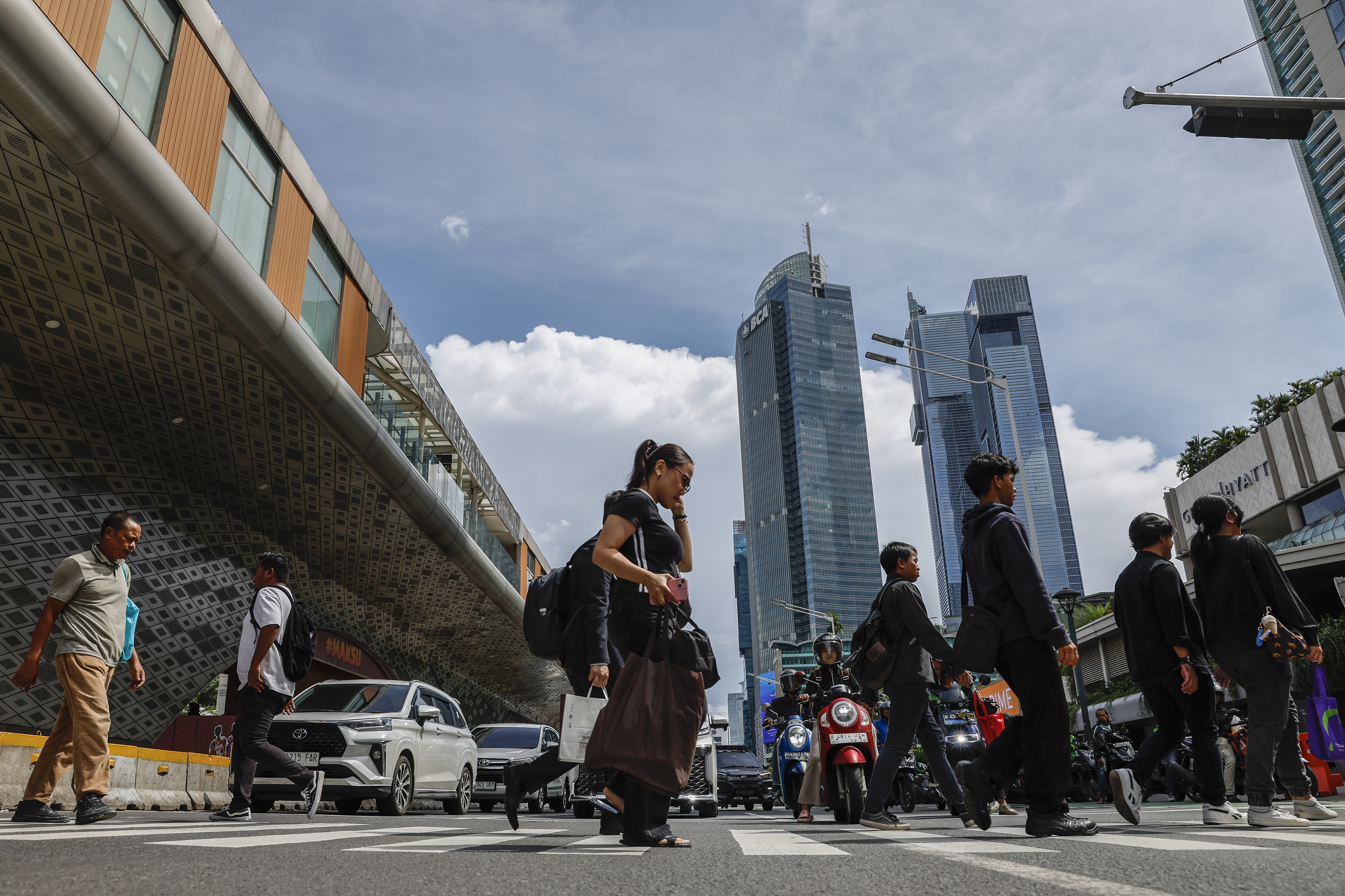 epa12530712 People cross a main street in Jakarta, Indonesia, 17 November 2025. According to Indonesia's Finance Minister Purbaya Yudhi Sadewa, the country’s economy is projected to grow six percent in 2026. EPA/MAST IRHAM