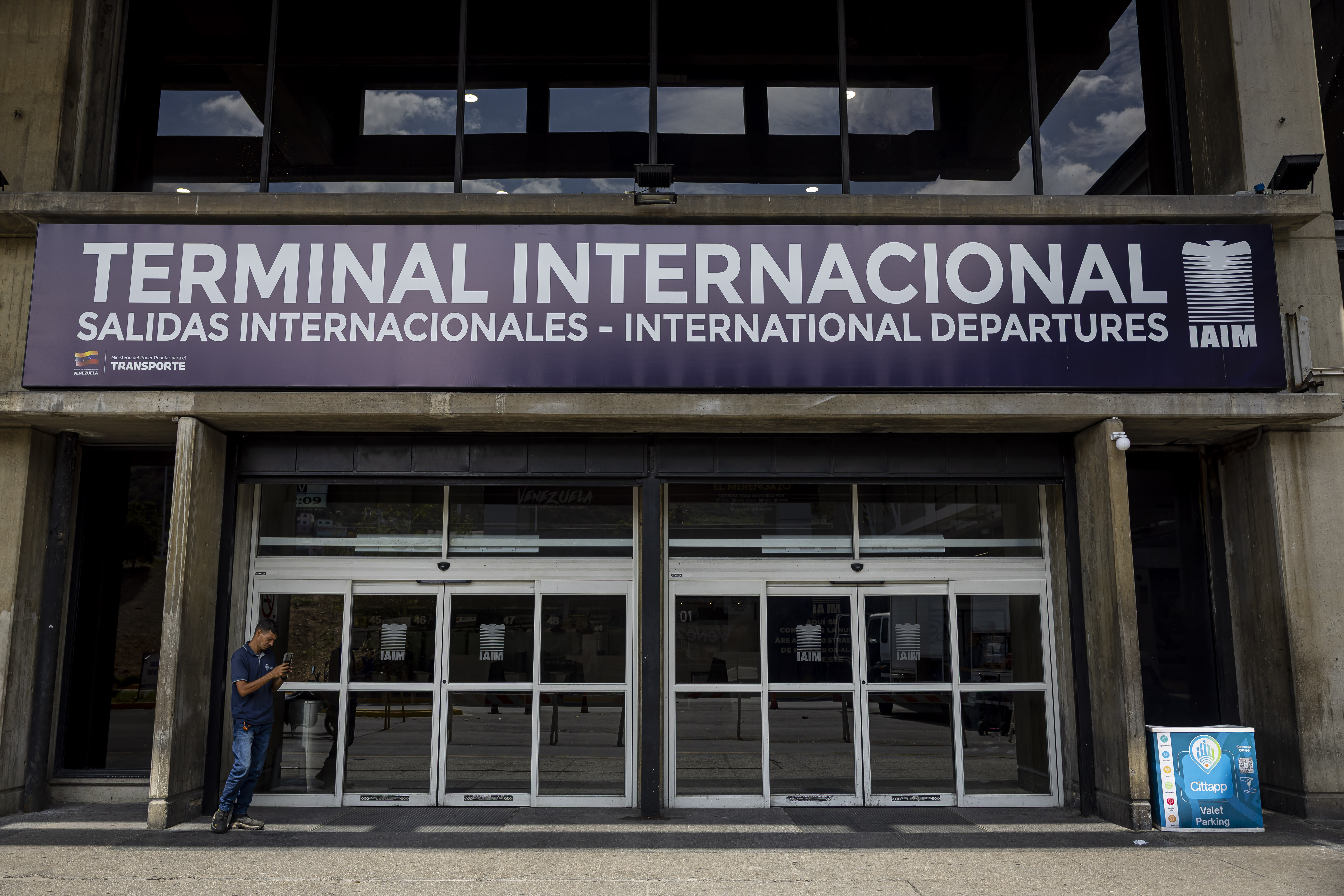 epa12553905 A person walks in front of Simon Bolivar International Airport in Maiquetia, Venezuela, 27 November 2025. The Maiquetia International Airport, which serves Caracas, operated with a limited schedule, with only seven departures and seven arrivals scheduled, one day after the Venezuelan authorities revoked the flight permits of six foreign airlines. EPA/Miguel Gutierrez