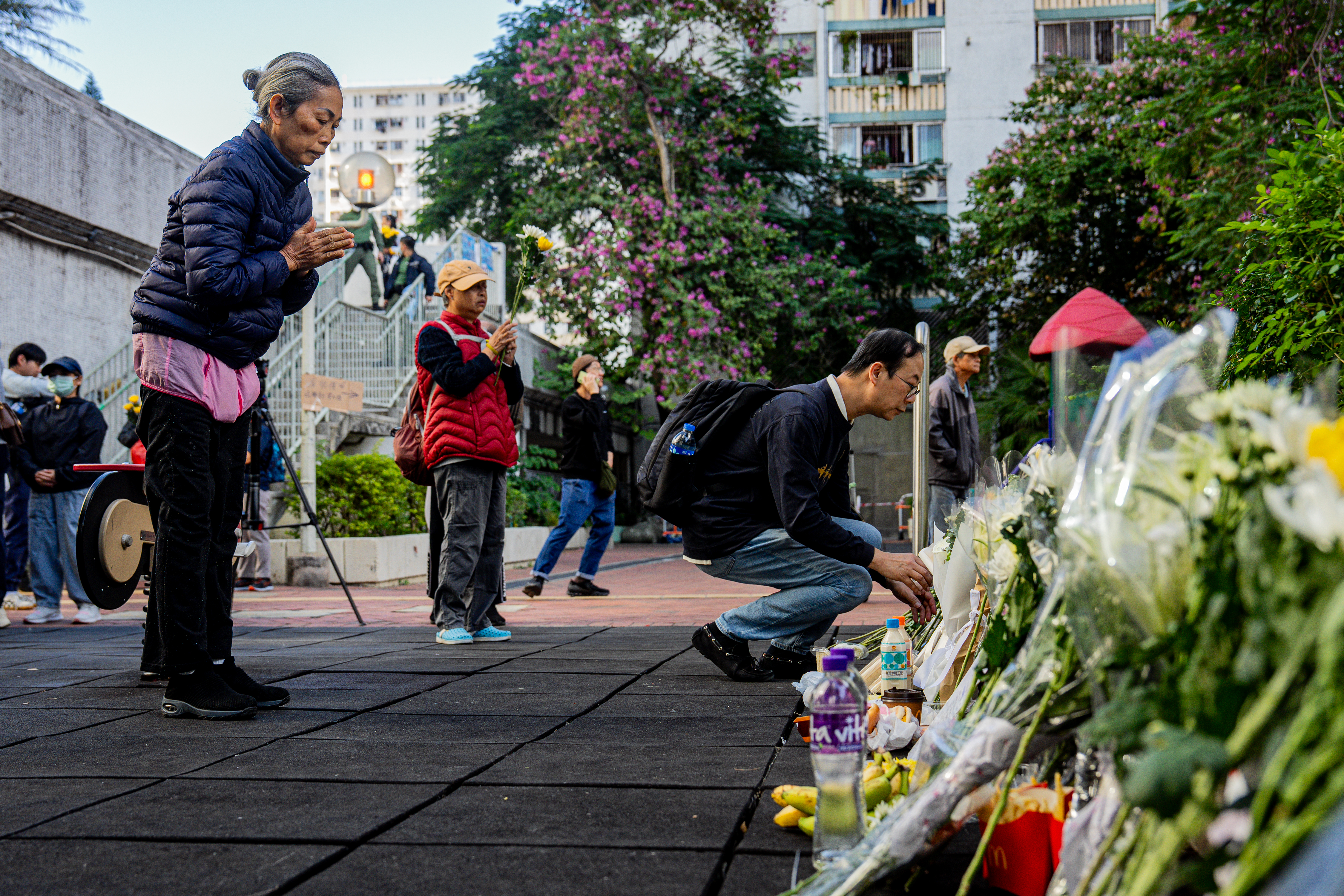 epa12556351 People lay floral tributes for the victims of the fire at the Wang Fuk Court residential estate in the Tai Po district of Hong Kong, China, 29 November 2025. The city is mourning 128 people killed in the high-rise apartment fire, with about 200 others still unaccounted for. EPA/LEUNG MAN HEI