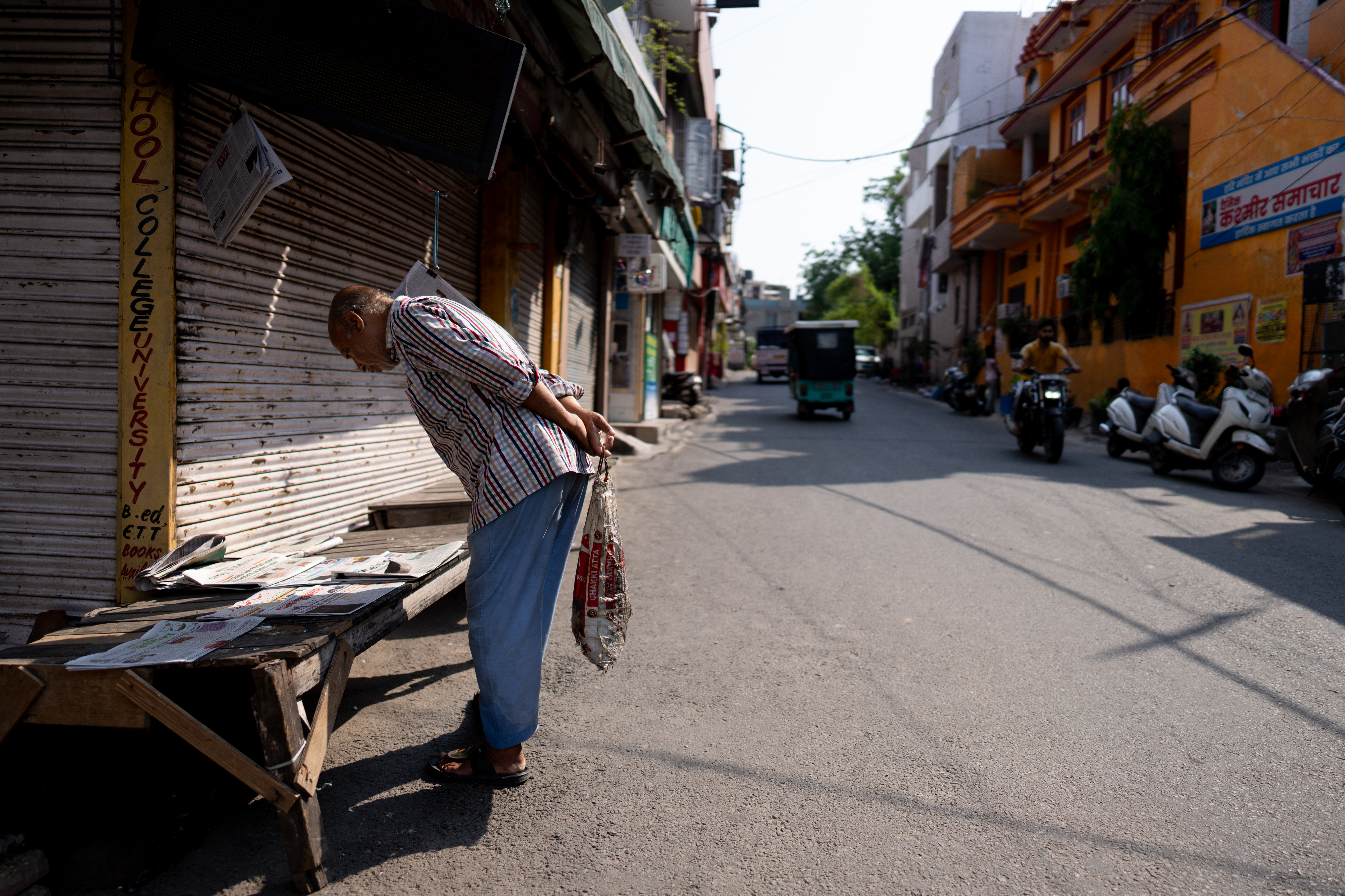 JAMMU, INDIA - MAY 10: An elderly man reads various local dailies kept for sale amid closed shutter shops, coinciding with the time when authorities sounded an alarm after two different residential buildings were damaged following an aerial attack from the Pakistan side on May 10, 2025, in Jammu, India. Tensions between India and Pakistan have sharply escalated following India's targeted strikes on alleged "terrorist infrastructure" inside Pakistan, which were carried out in retaliation for a deadly attack in Indian-administered Kashmir last month. Both sides have since exchanged drone and missile attacks along the border, resulting in dozens of fatalities and widespread disruption, with each nation vowing further action while international mediators urge de-escalation. (Photo by Anindito Mukherjee/Getty Images)