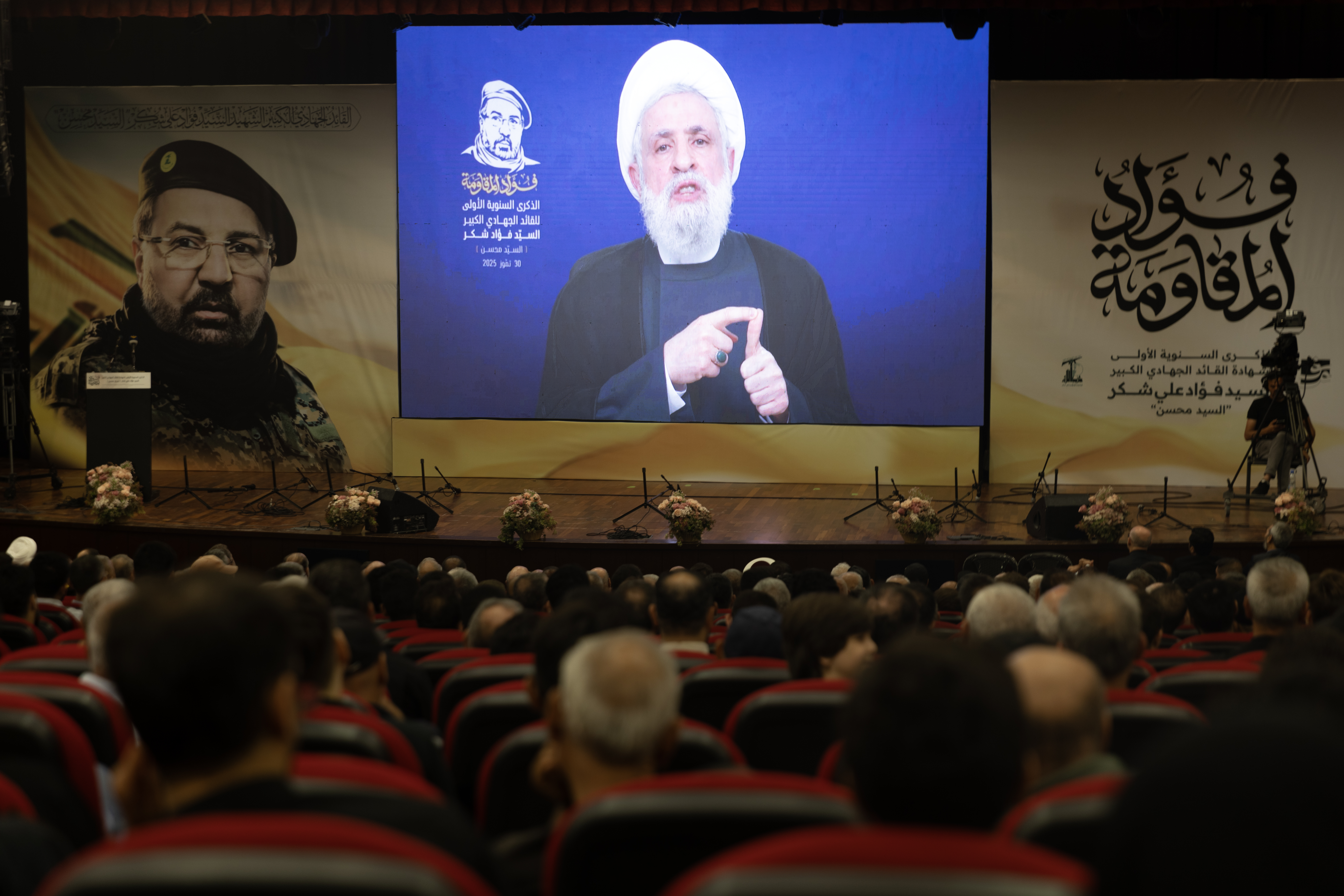 HADATH, LEBANON - JULY 30: Hezbollah leader Naim Qassem delivers a televised speech at a ceremony commemorating the first anniversary of the death of Fuad Shukr on July 30, 2025 in Hadath, near Beirut, Lebanon. Shukr was a senior Hezbollah commander who was killed in a strike by Israel in Beirut on July 30, 2024. He was reported to be a close adviser to the group's former leader Hassan Nasrallah, and was also wanted by the U.S. government in relation to a 1983 bombing in Beirut that killed hundreds of American and French soldiers. Shukr also went by the nom de guerre al-Hajj Mohsin. (Photo by Daniel Carde/Getty Images)