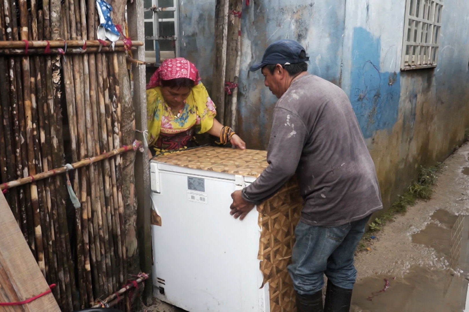 Two members of Panama&#039;s indigenous Guna community move an appliance as they relocate from the island of Gardi Sugdub to the newly built Isberyala on the mainland. [Al Jazeera]