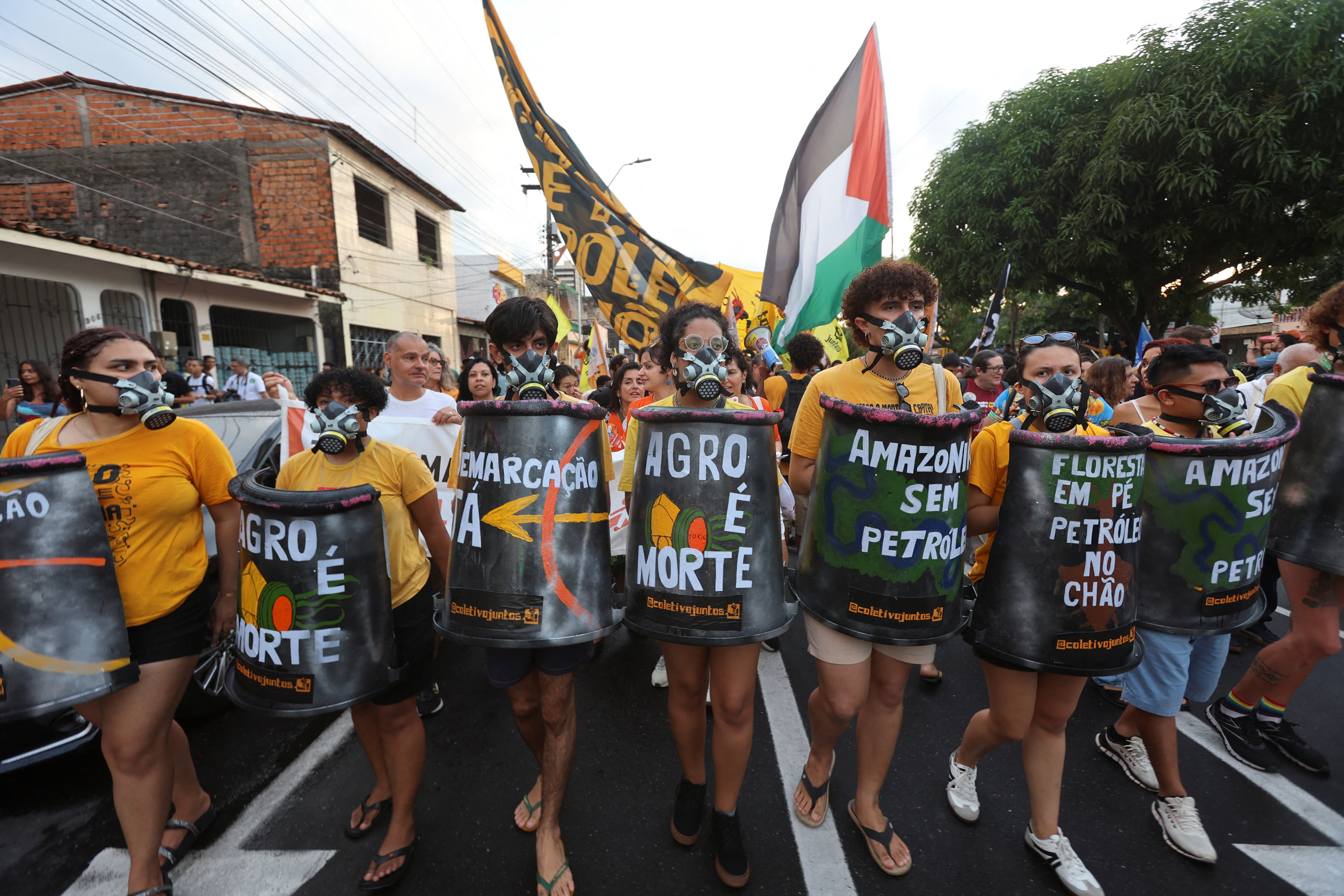 Demonstrators march wearing gas masks on the sidelines of the UN Climate Change Conference (COP30), in Belem, Brazil, November 11, 2025. REUTERS/Anderson Coelho