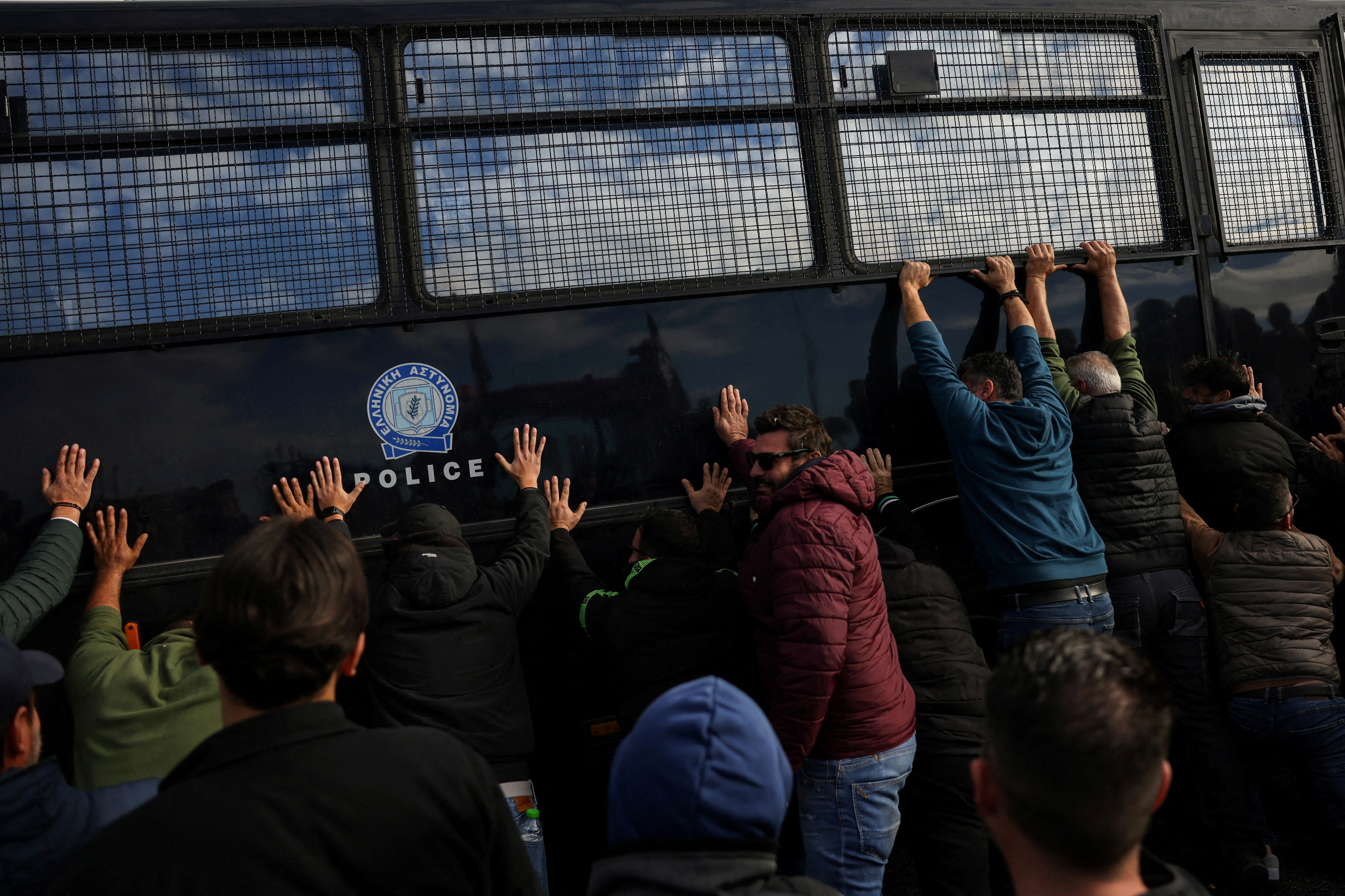 Protesting farmers try to overturn a riot police vehicle in Nikaia, near Larissa, Greece, November 30, 2025.