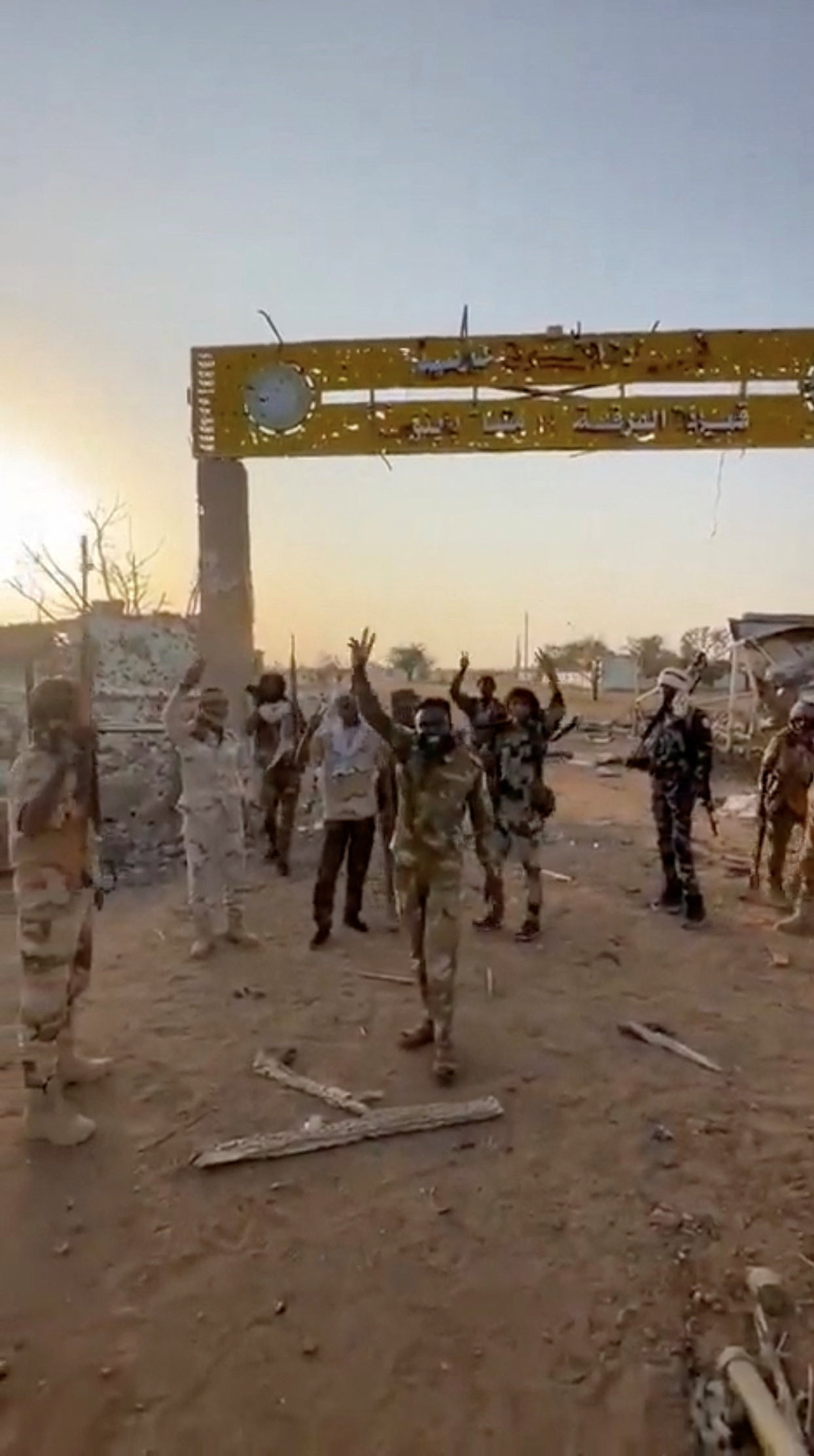 Members of Sudan's paramilitary Rapid Support Forces (RSF) stand in front of the main gate of the 22nd SAF Infantry Division, in Babanusa, Sudan
