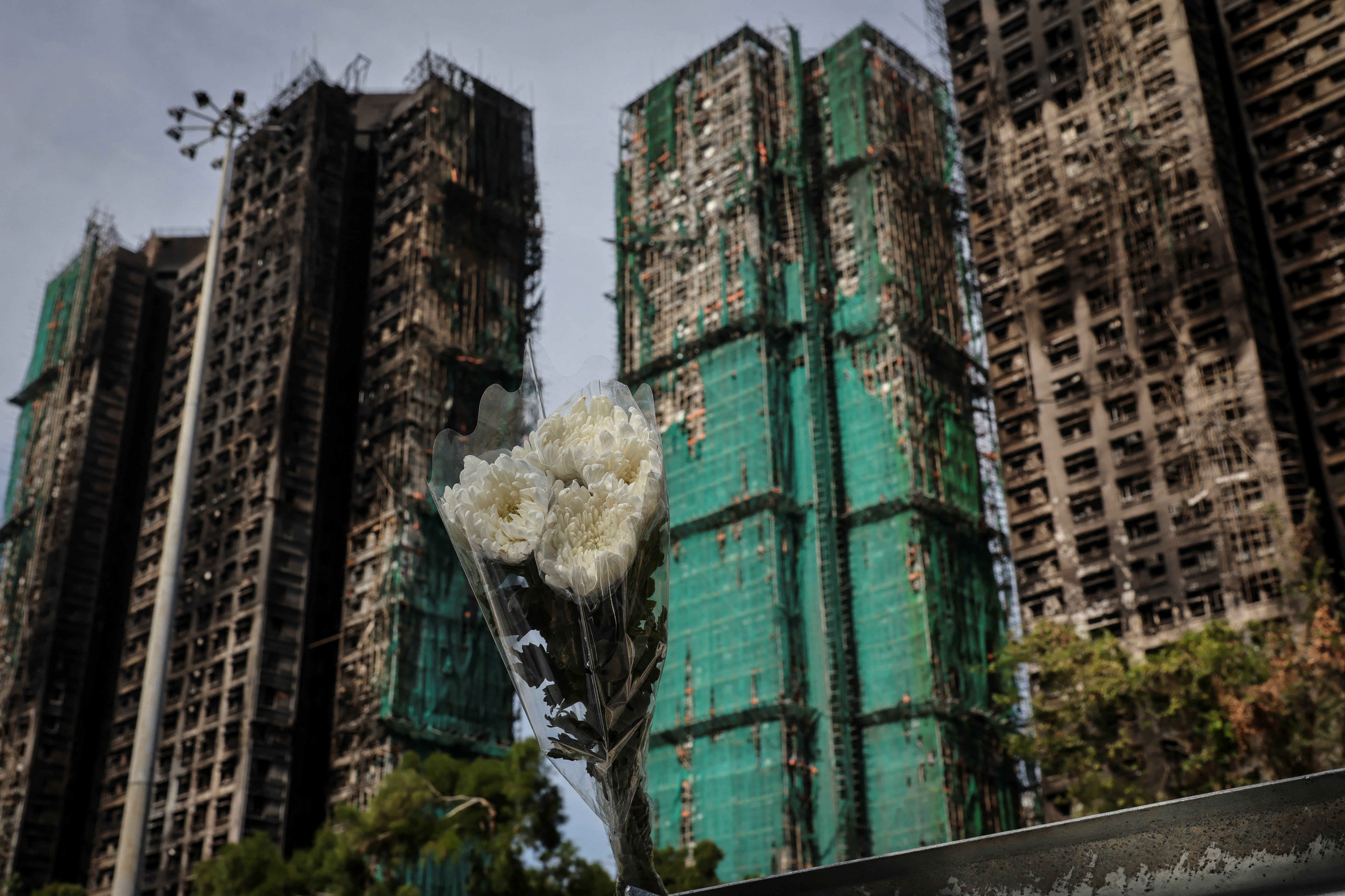 A flower bouquet is placed at the scene of the Wang Fuk Court housing complex fire.
