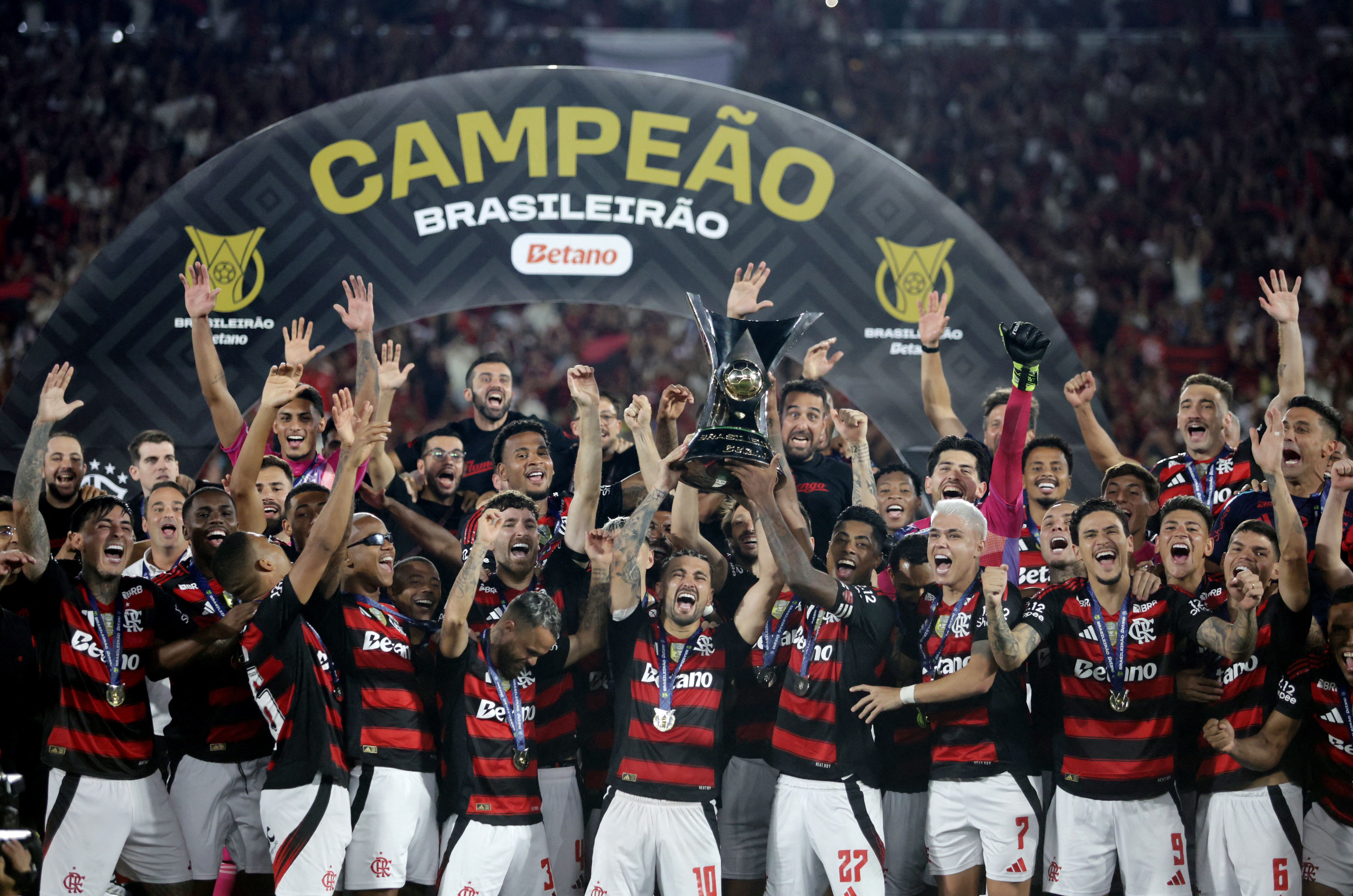 Flamengo's Giorgian de Arrascaeta and Bruno Henrique lift the trophy as they celebrate with teammates after winning the Brasileiro Championship