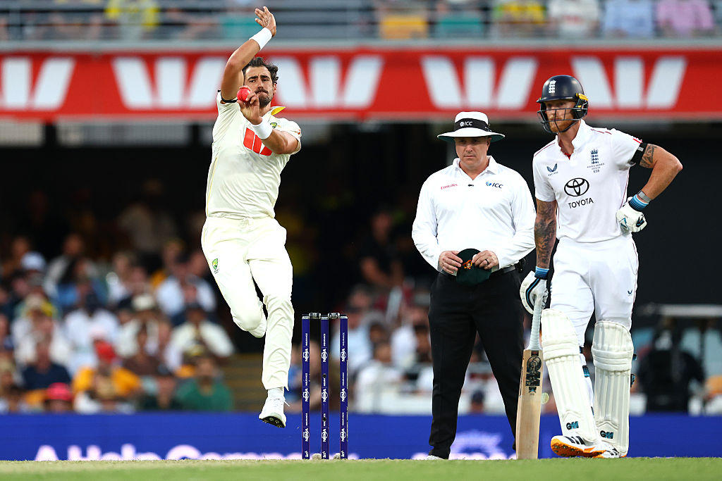 Mitchell Starc of Australia bowls during day one of the Second 2025/26 Ashes Series Test Match as England captain Ben Stokes watches on