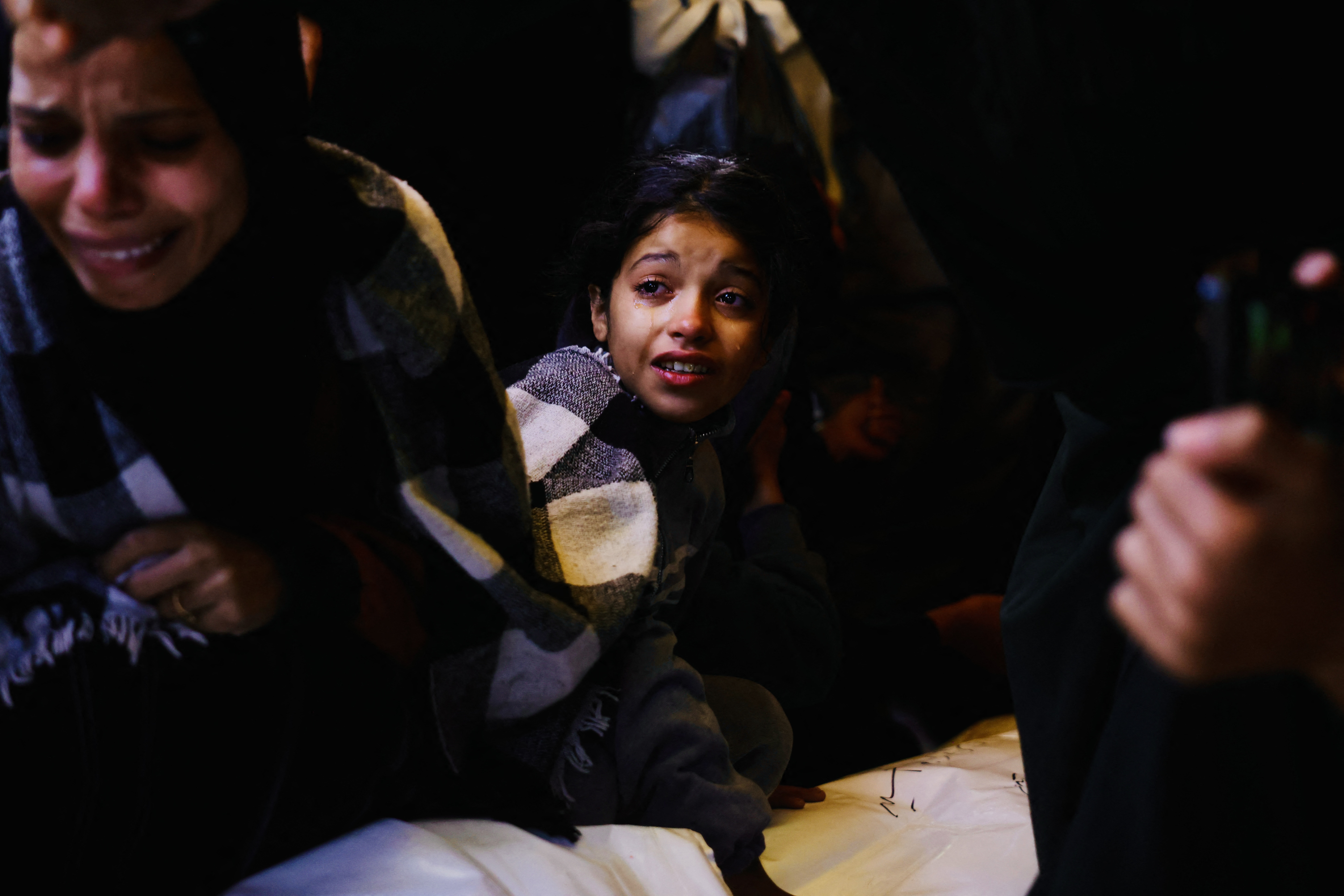Mourners react as they attend the funeral of Palestinians killed on December 3, by an Israeli strike, at Nasser Hospital in Khan Yunis, southern Gaza Strip on December 4, 2025.