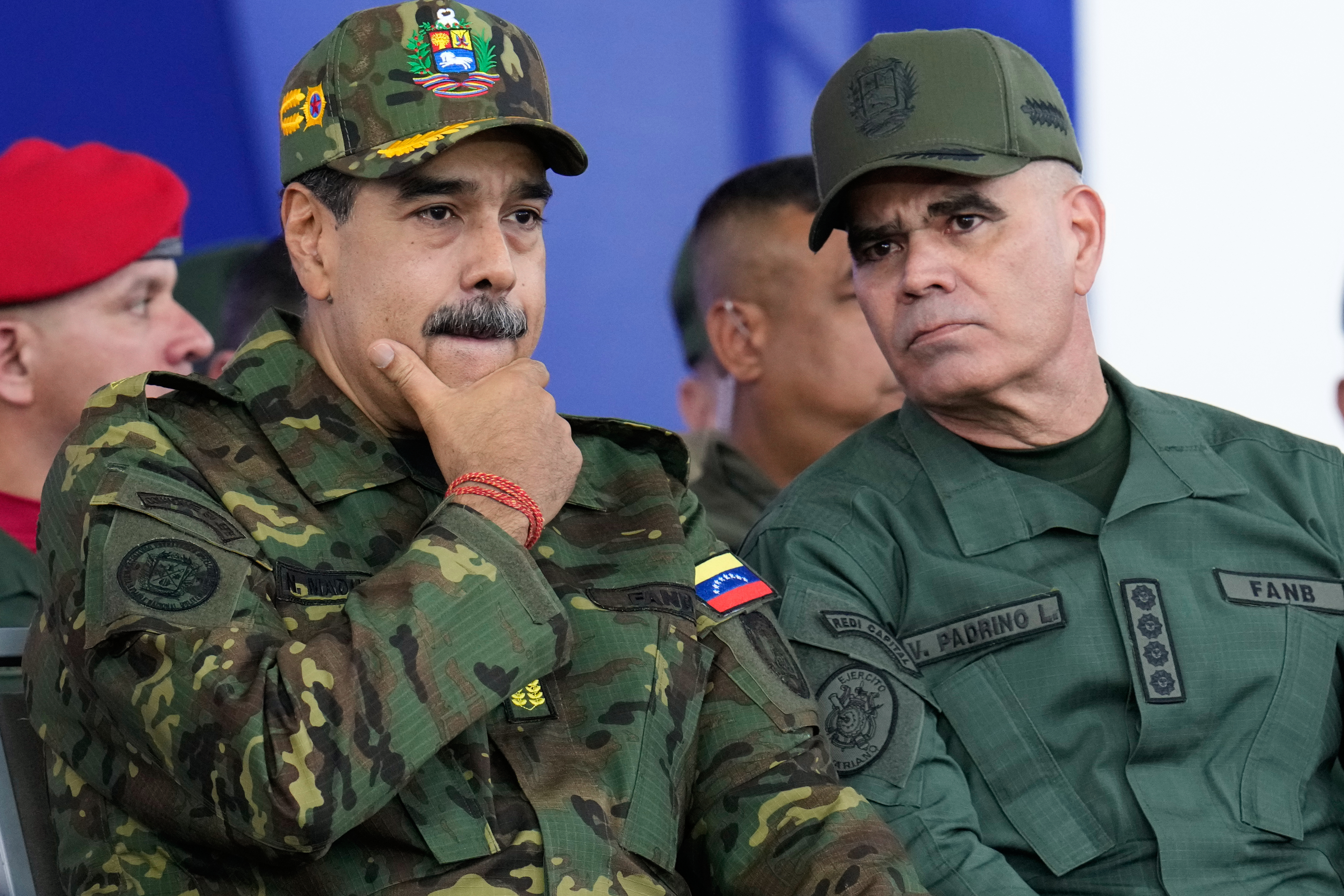 Venezuelan President Nicolas Maduro, left, listens to Defense Minister Vladimir Padrino Lopez during a government-organized civic-military march in Caracas, Venezuela, Tuesday, Nov. 25, 2025. (AP Photo/Ariana Cubillos)
