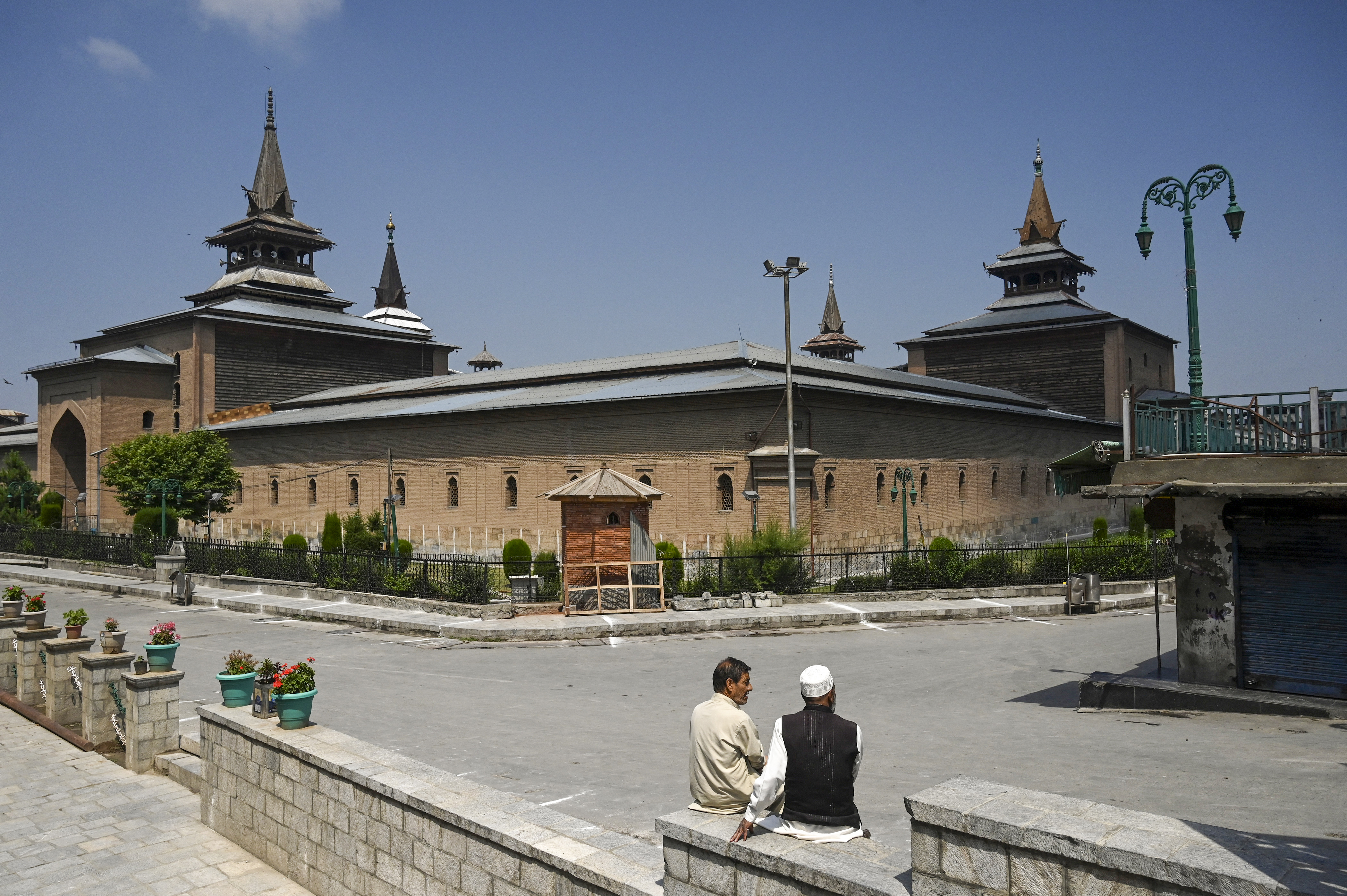 Elderly people sit in front of Srinagar's mosque Jamia Masjid