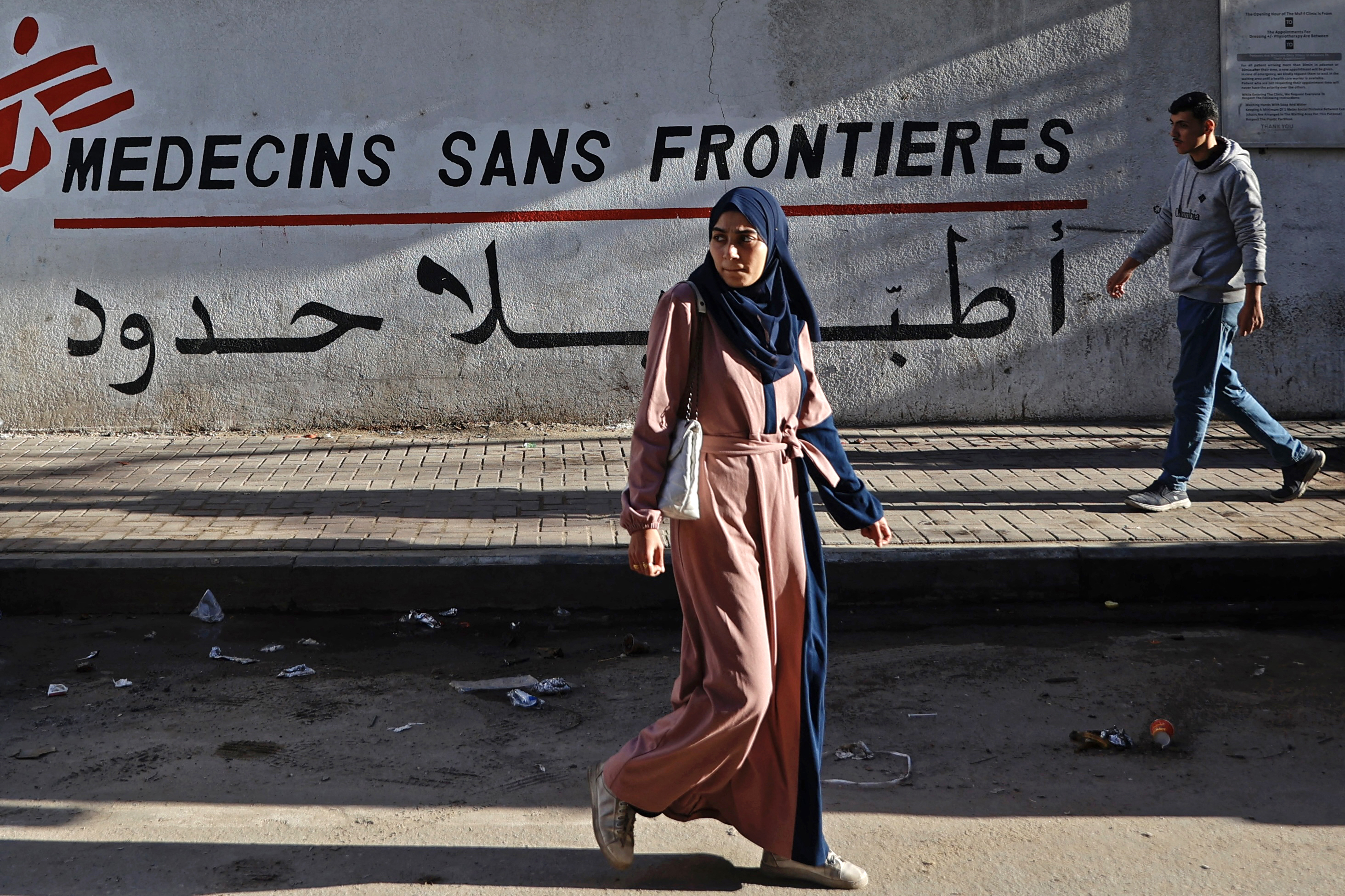 Palestinians walk past the clinic of Doctors Without Borders in the Remal neighbourhood of Gaza City on January 11, 2026 [Omar Al-Qattaa/AFP]