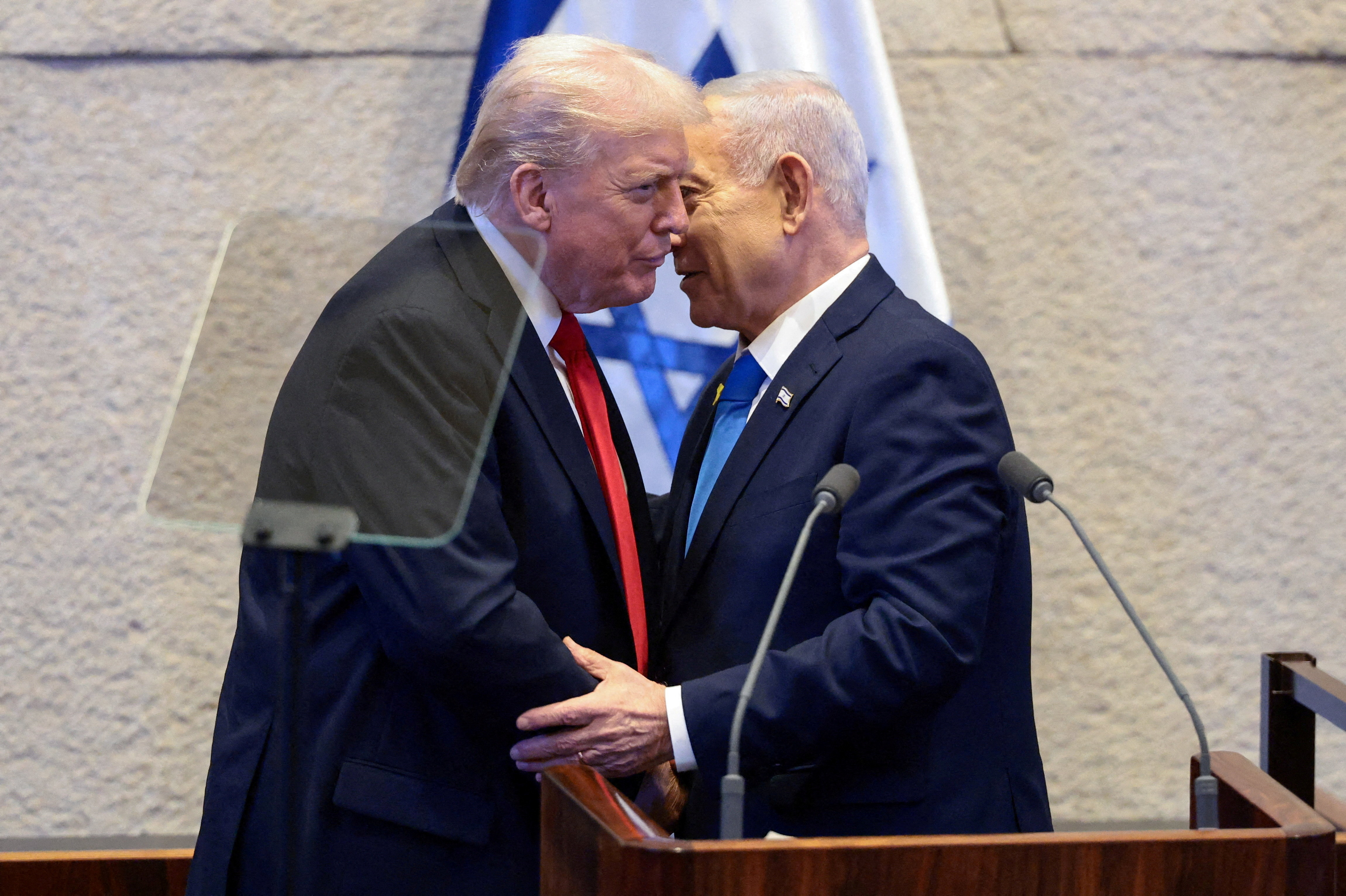 FILE PHOTO: U.S. President Donald Trump and Israeli Prime Minister Benjamin Netanyahu stand at the Knesset on the day Trump addresses it, amid a U.S.-brokered prisoner-hostage swap and ceasefire deal between Israel and Hamas, in Jerusalem, October 13, 2025. REUTERS/Evelyn Hockstein/Pool/File Photo
