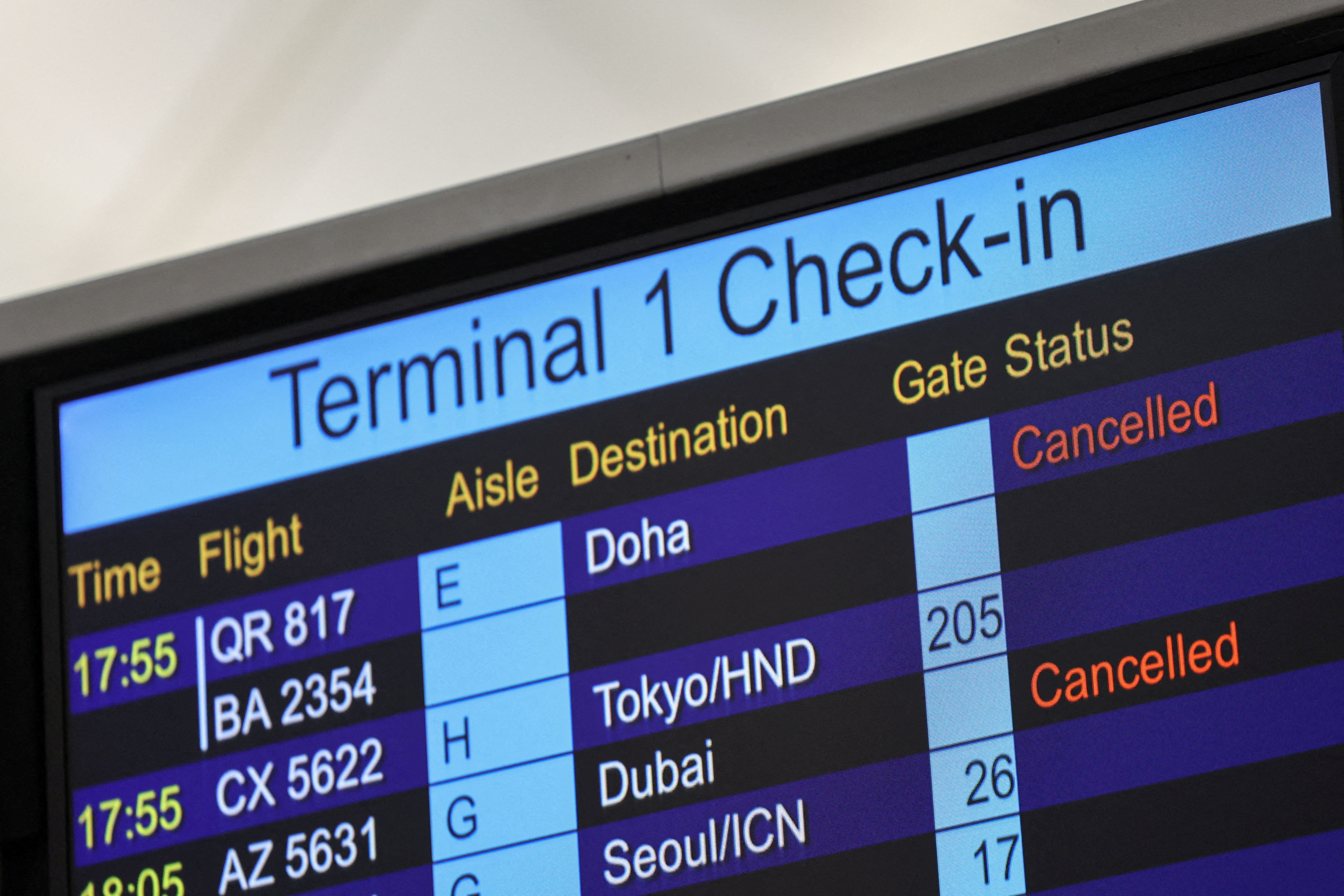 A screen displays cancelled flights to Middle East destinations at the Hong Kong International Airport in Hong Kong, China