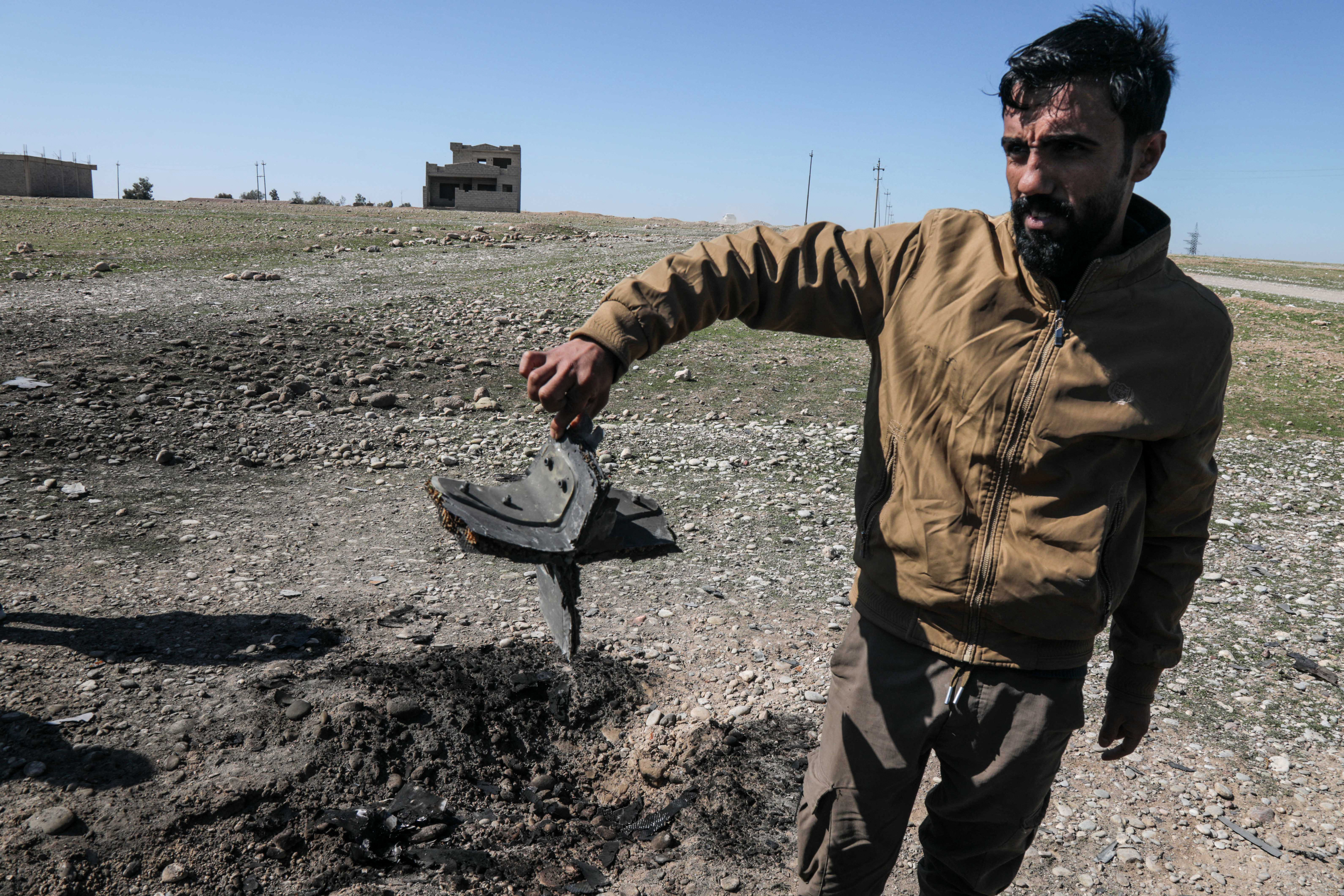 A man shows the remains of a drone that was reportedly aimed at Erbil International Airport and crashed outside Erbil, the capital of the autonomous Kurdish region of northern Iraq, on March 3, 2026.
