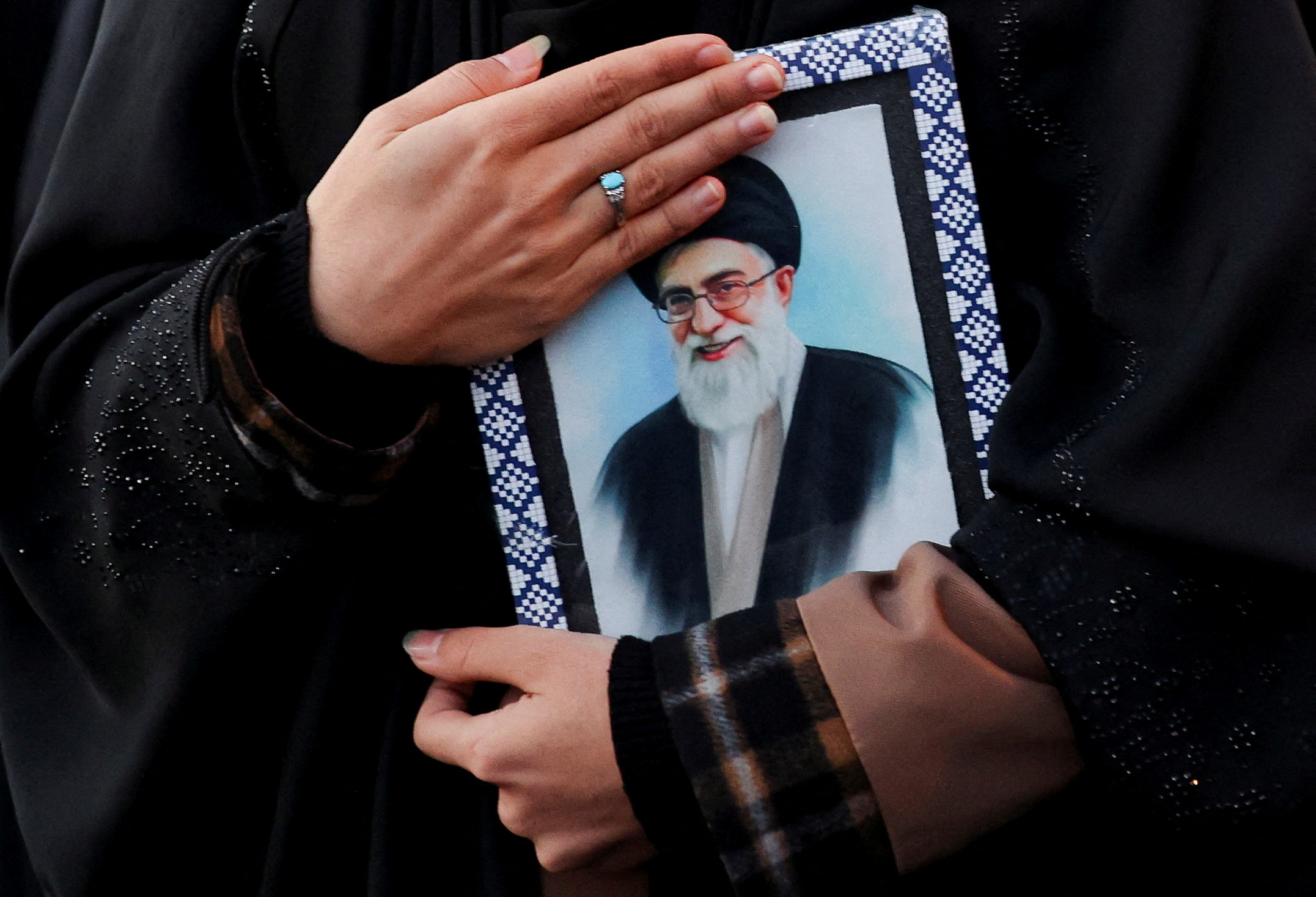 FILE PHOTO: A woman holds on to a picture of Iran's Supreme Leader Ayatollah Ali Khamenei.