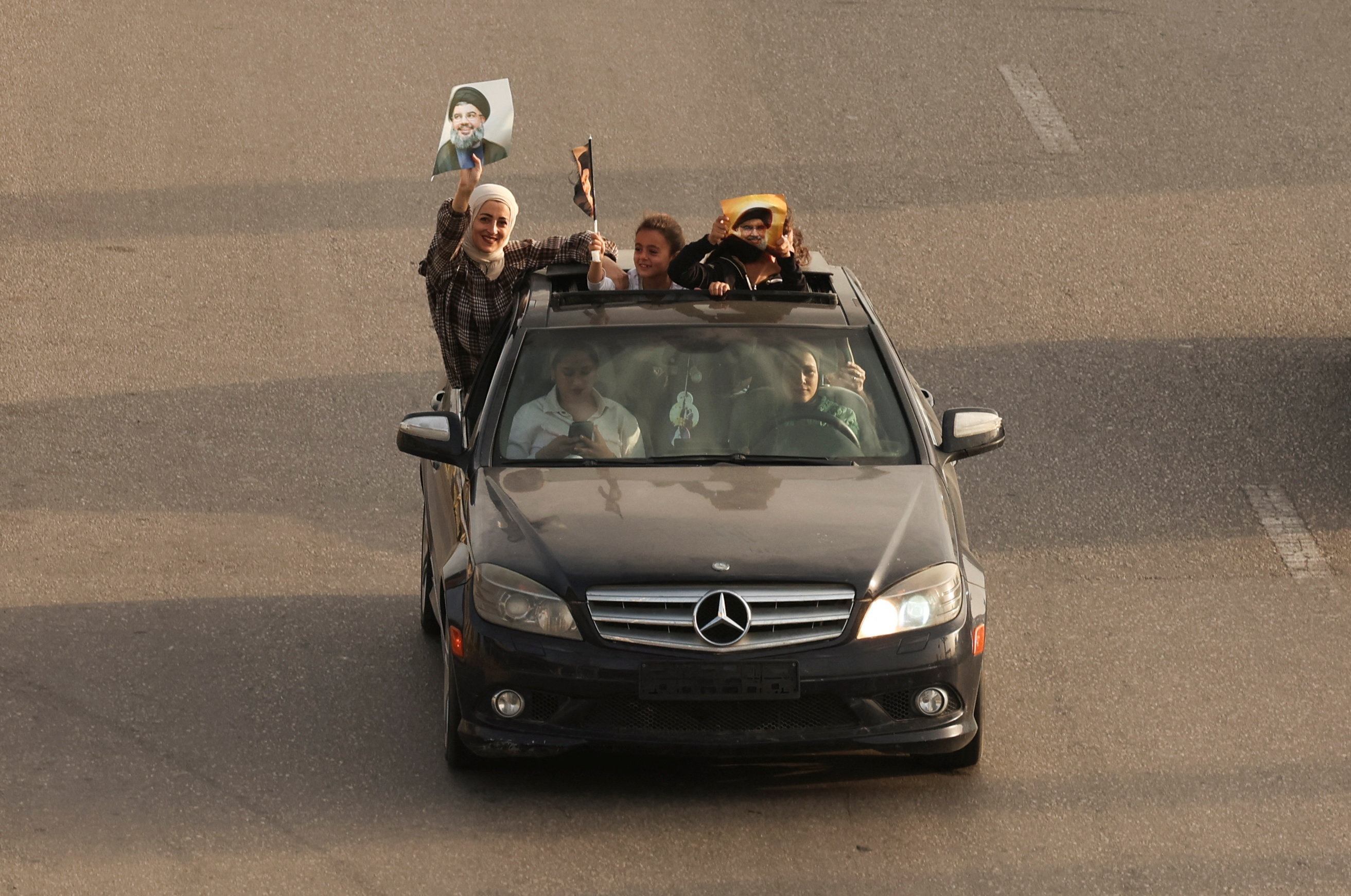 People in vehicles hold up posters depicting former Hezbollah leaders Hassan Nasrallah and Hashem Safieddine, after a 10-day ceasefire between Lebanon and Israel went into effect, in Sidon, Lebanon, April 17, 2026. REUTERS/Aziz Taher