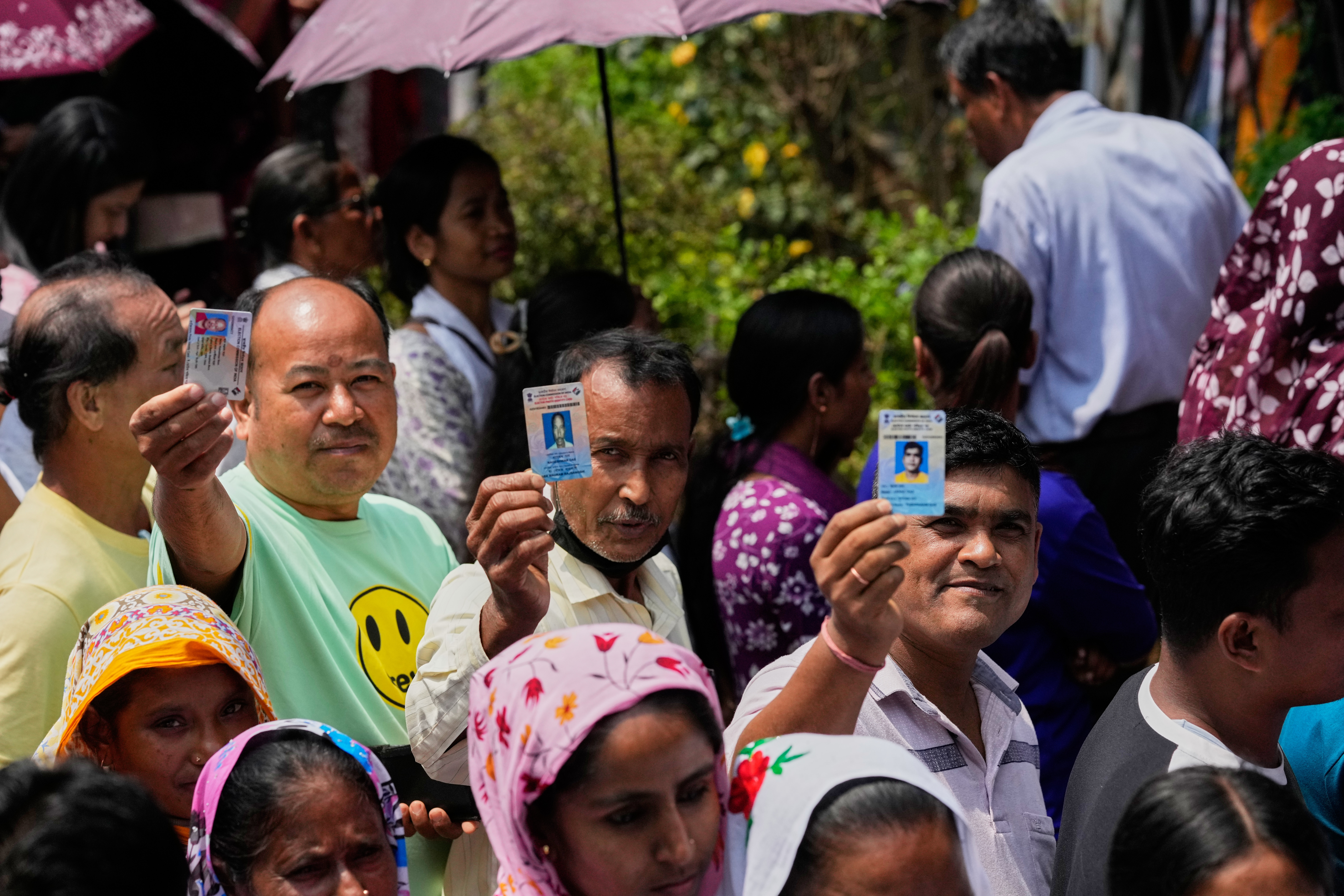 People standING in queue to cast their votes show identity cards at a polling centre during the Assam state election in Guwahati, India, Thursday, April 9, 2026