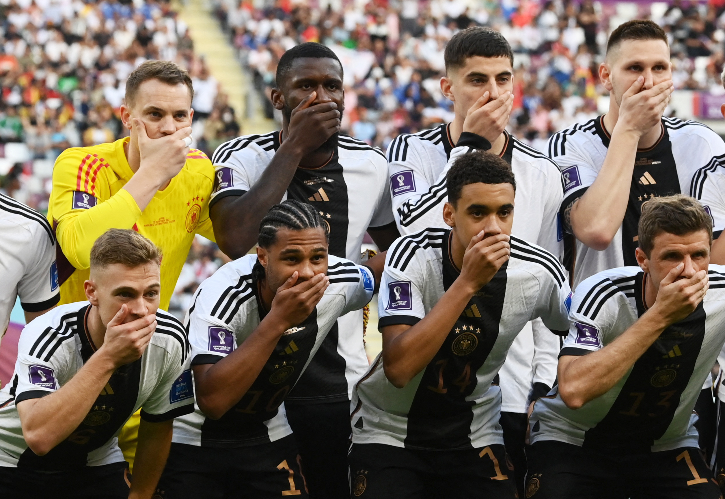 Germany players cover their mouths as they pose for a team group photo before a World Cup match in2022