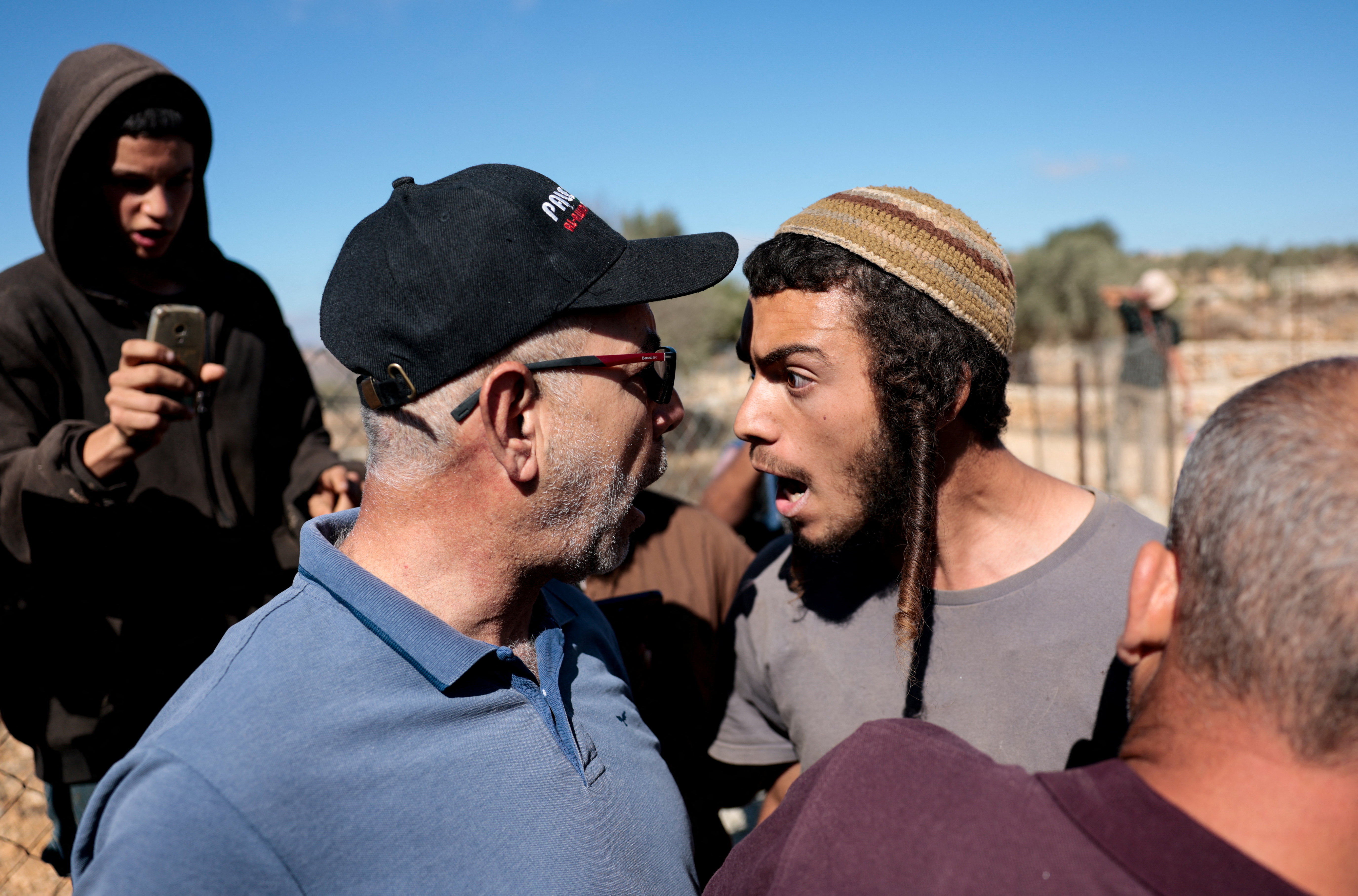 An Israeli settler argues with a Palestinian farmer.
