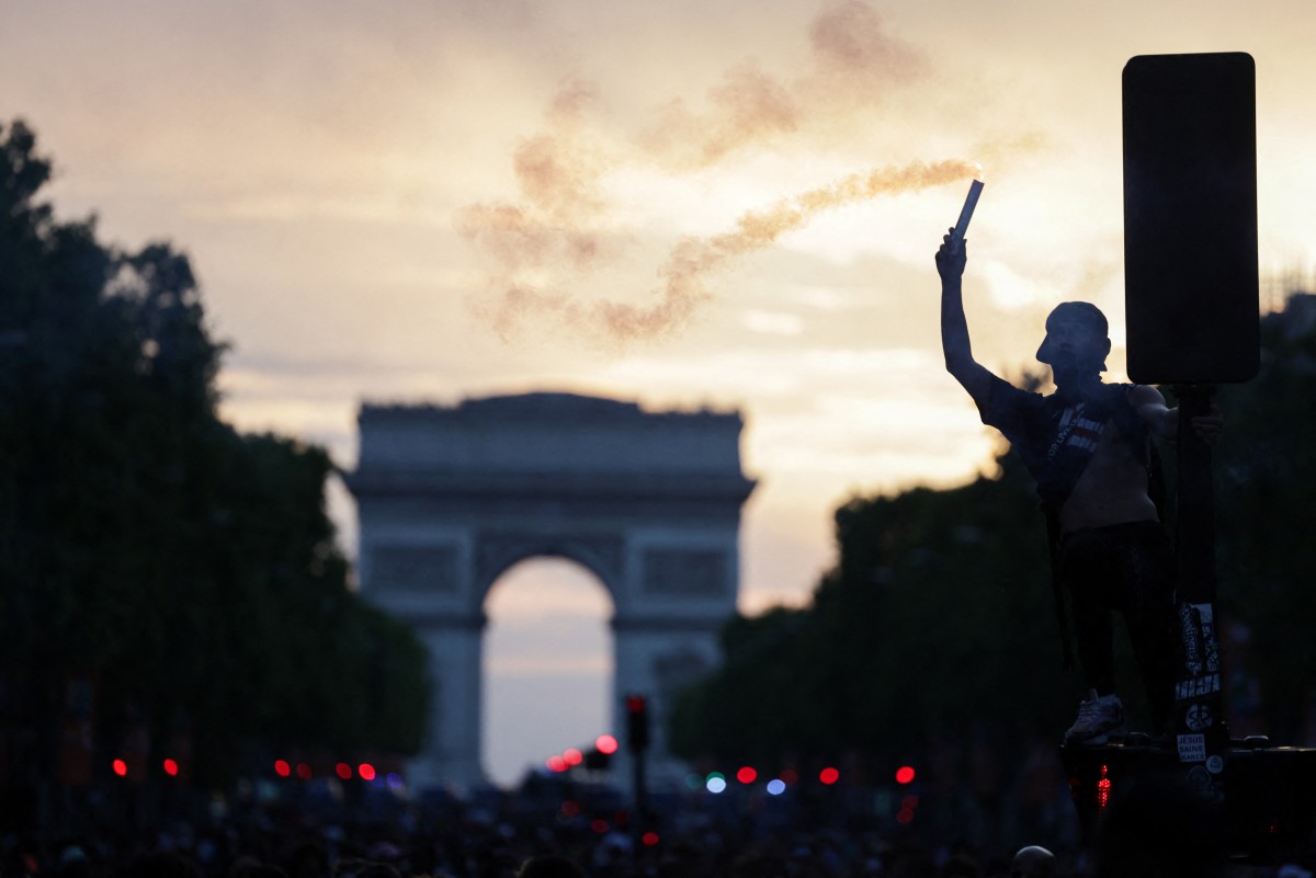 PSG supporters celebrate on the Champs-Elysees Avenue after their team's win in the UEFA Champions League final football match between Paris Saint-Germain (PSG) and Arsenal