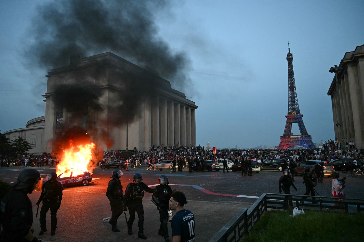 A car is set ablaze as PSG supporters celebrate their team's win in the UEFA Champions League final between Paris Saint-Germain (PSG) and Arsenal