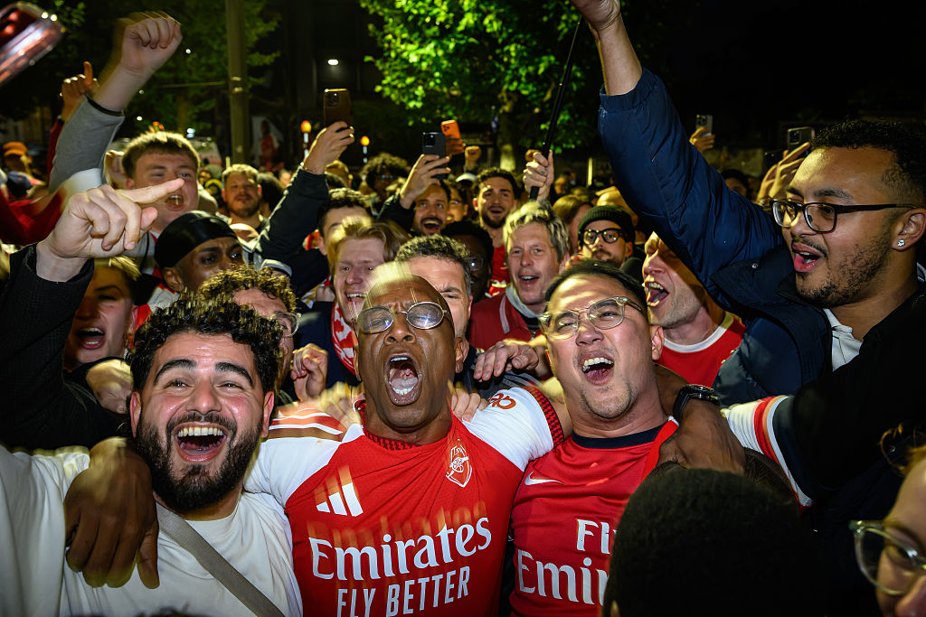 English media personality and former Arsenal footballer Ian Wright celebrates with supporters at Emirates Stadium as Arsenal take the Premier League title