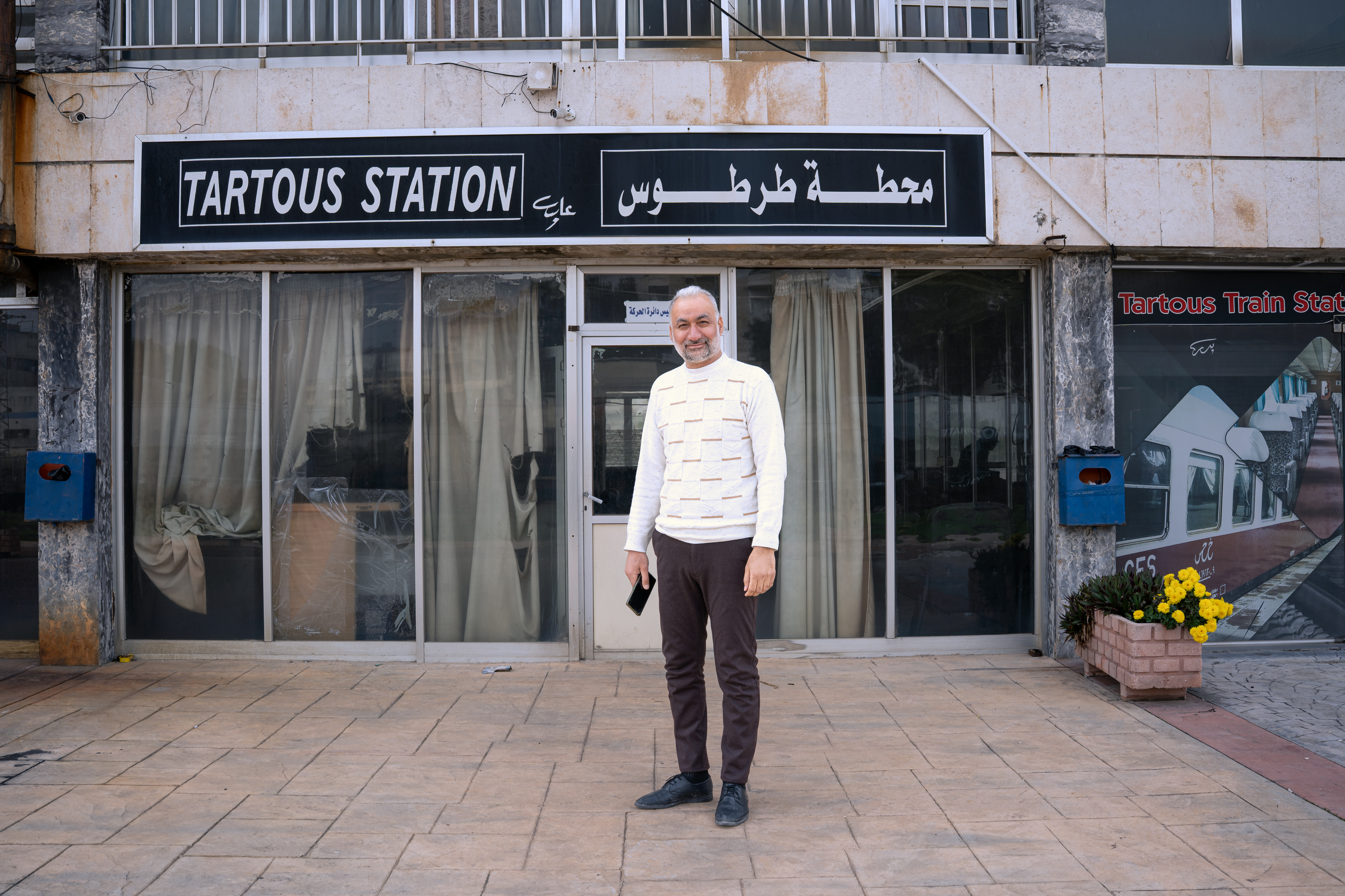 Nidal Abdulkader, head of the Syrian General Railway Corporation's railway network in the Tartous governorate, stands outside the Tartous station [Charles Cuau/Al Jazeera]