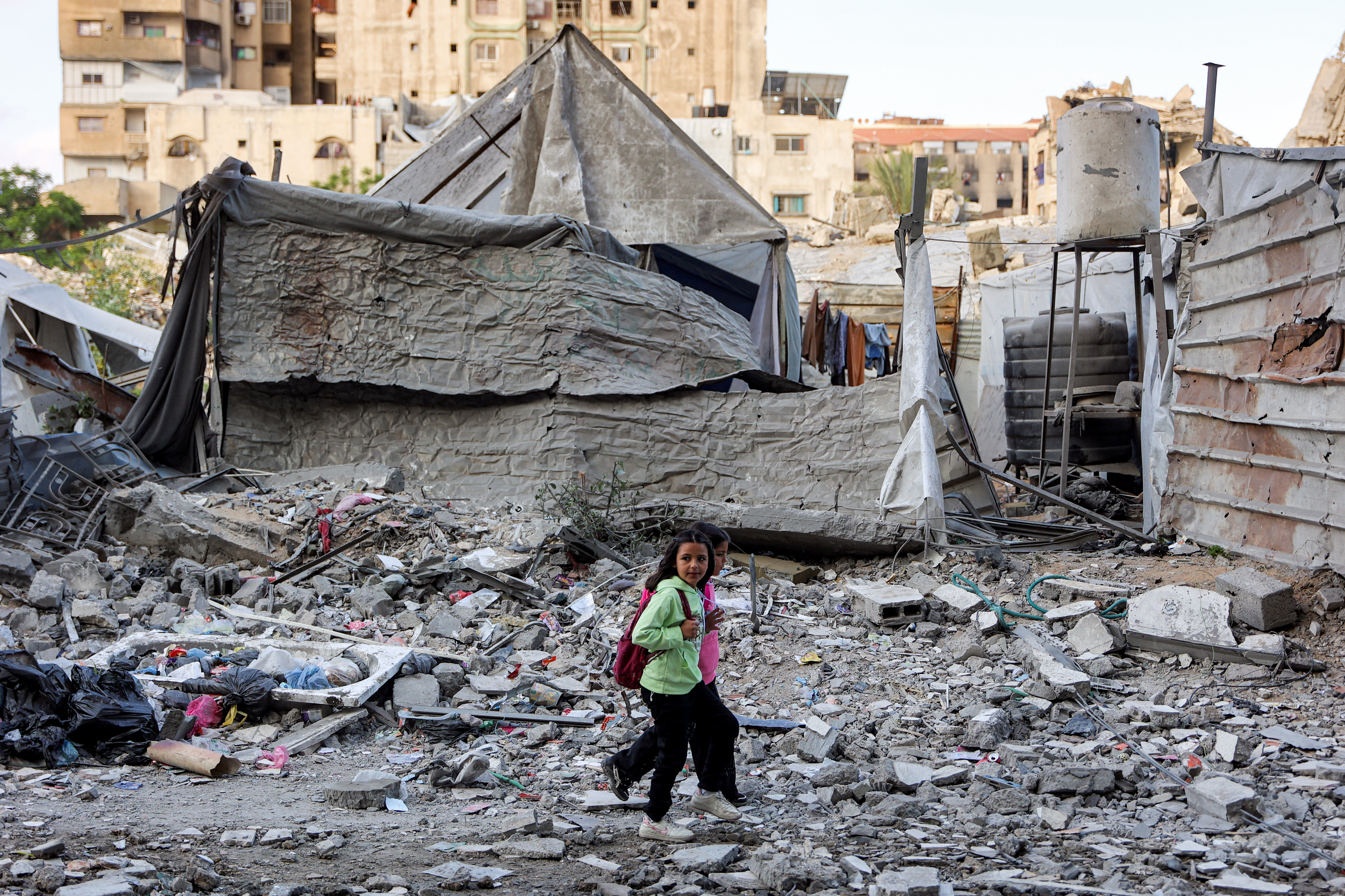 Children walk outside a residential building that was hit by an Israeli strike the previous day in the Rimal neighbourhood of Gaza City on May 16, 2026.