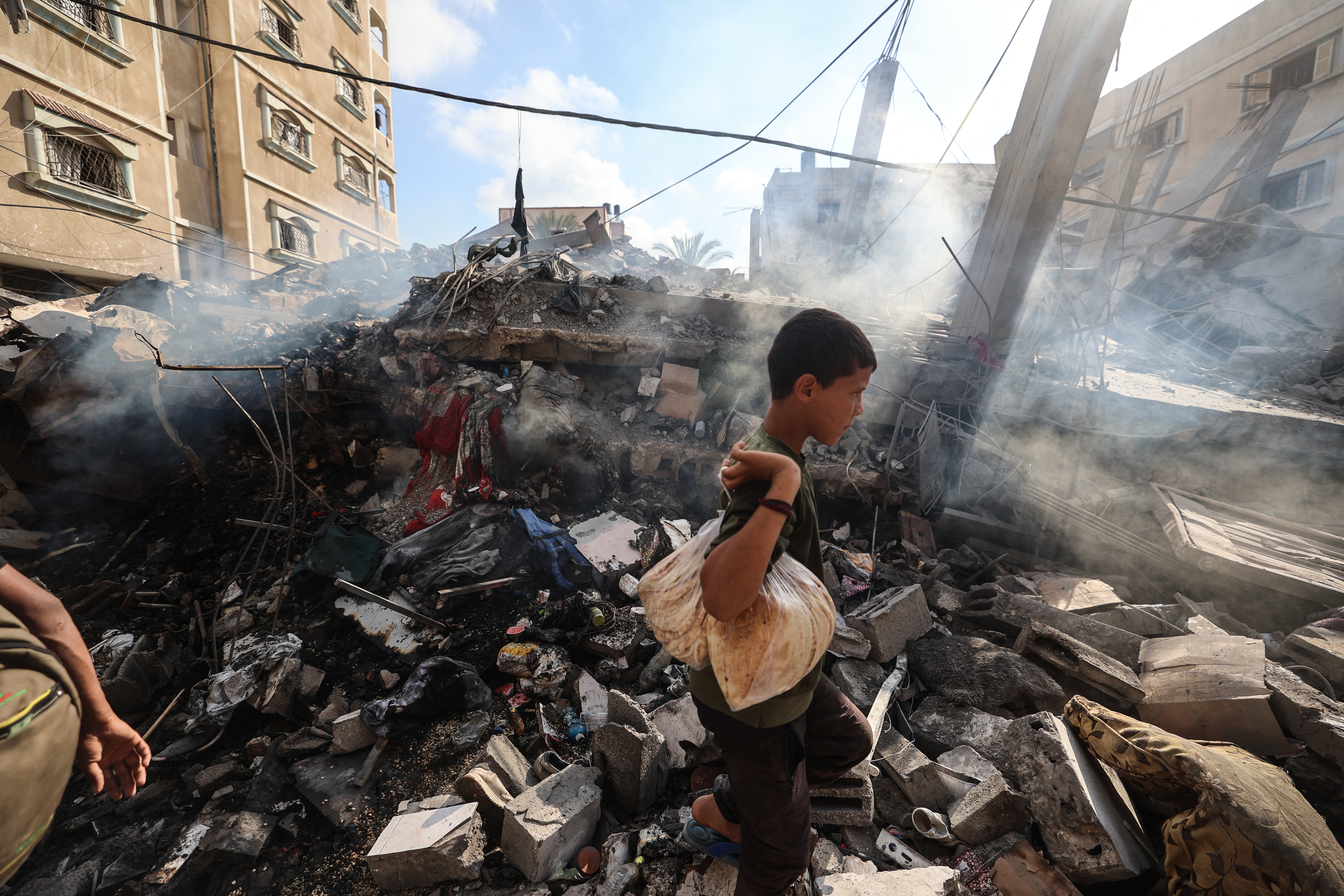 A Palestinian boy stands by the rubble of a residential building targeted overnight by an Israeli strike in Deir el-Balah in central Gaza