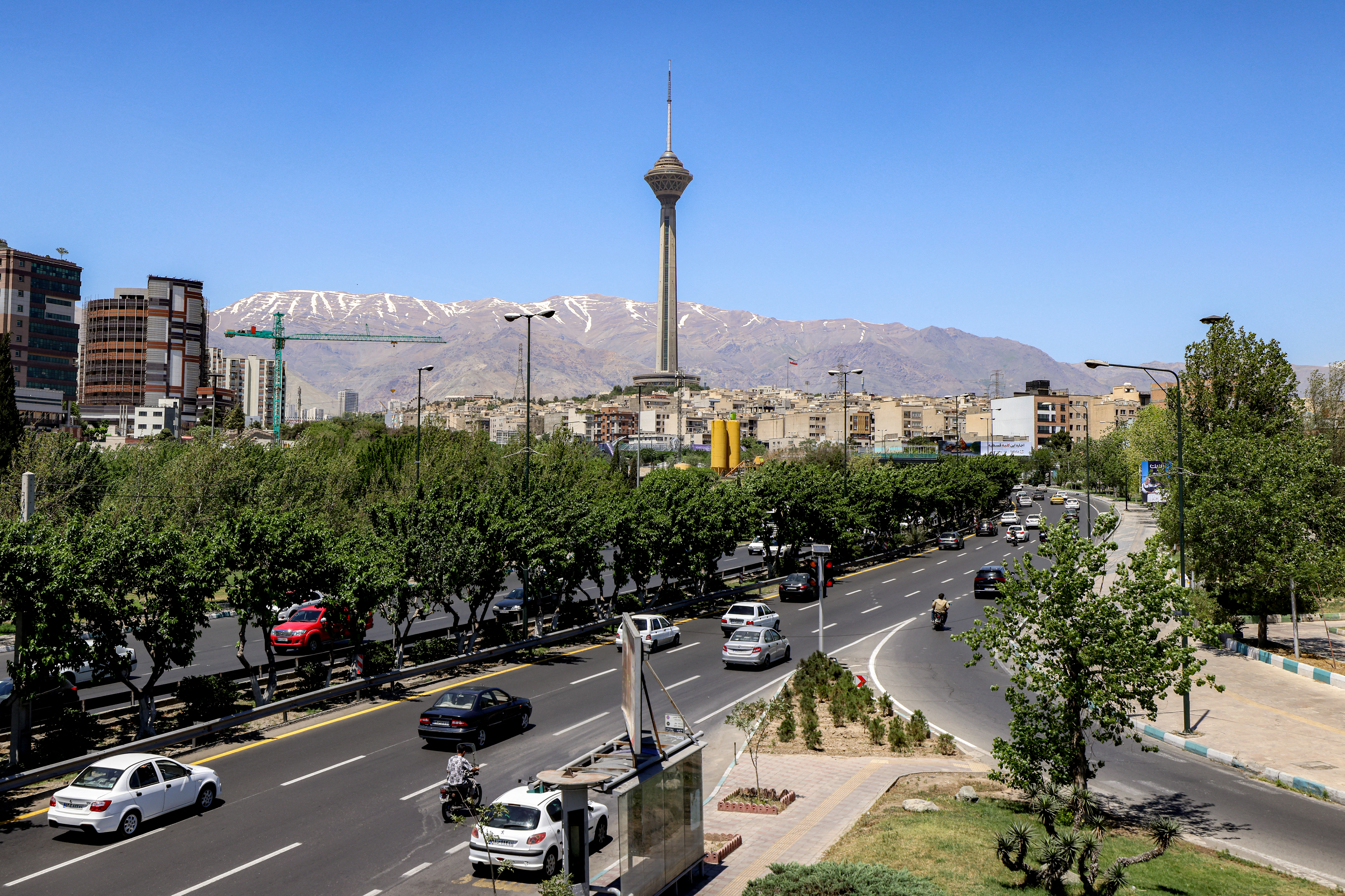 Motorists drive their vehicles along a road near Milad (Birth) Tower, the tallest tower in the country at 435 metres and part of Tehran's International Trade and Convention Centre, in Tehran on May 26, 2026.