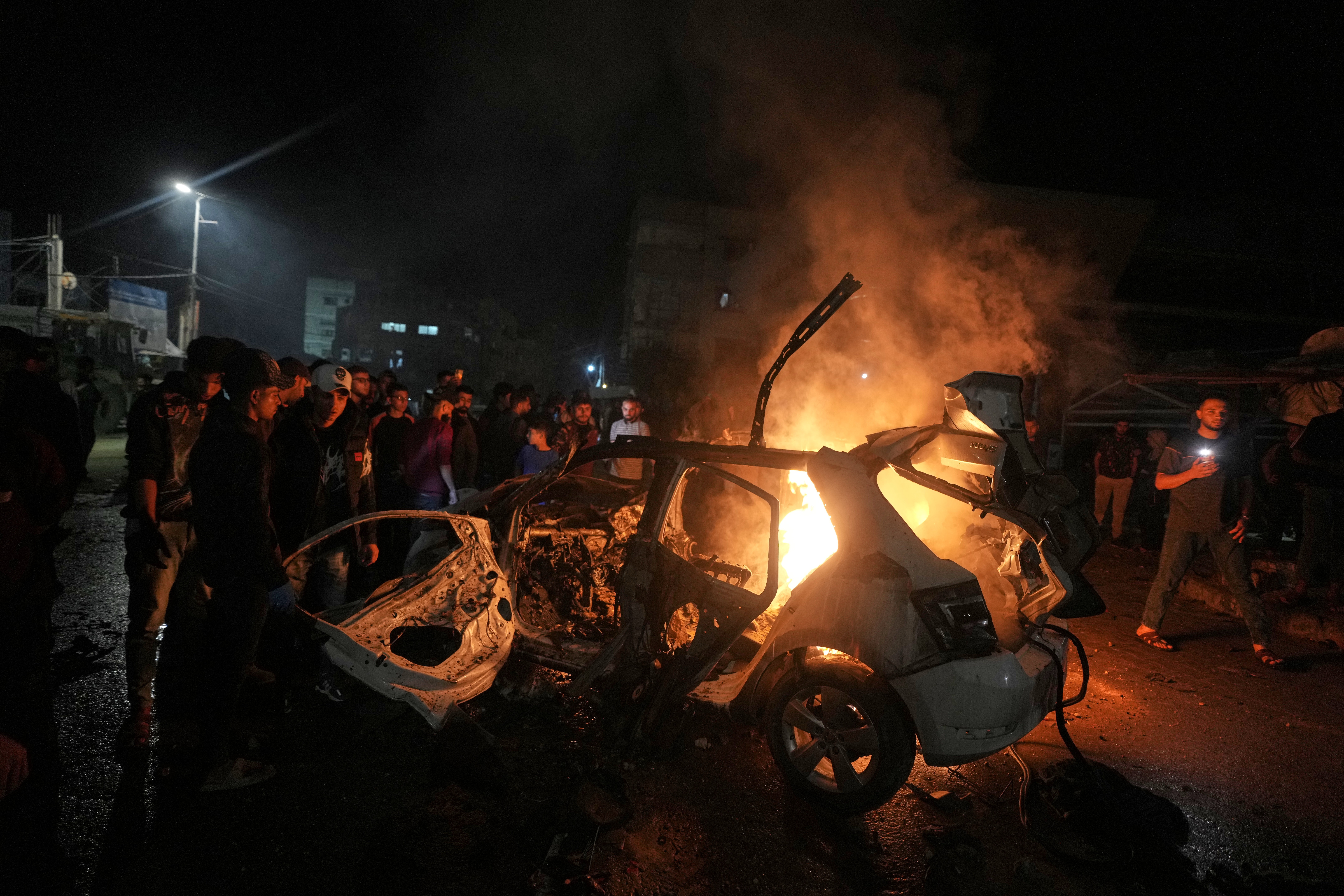 Palestinians gather around a vehicle struck by an Israeli strike in Gaza City, Friday, May 15, 2026. (AP Photo/Jehad Alshrafi)