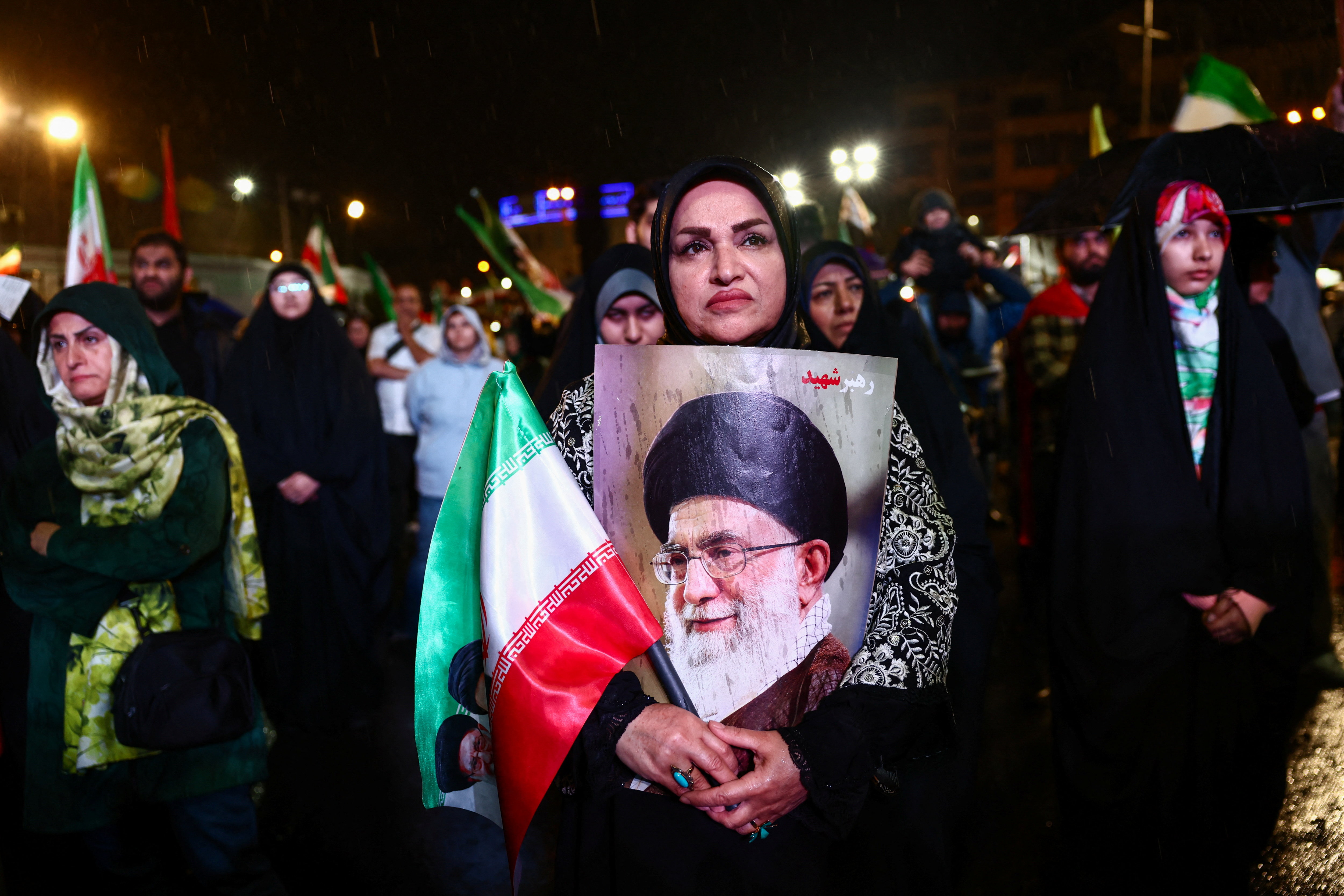 A woman holds a poster of Iran’s late Supreme Leader Ayatollah Ali Khamenei