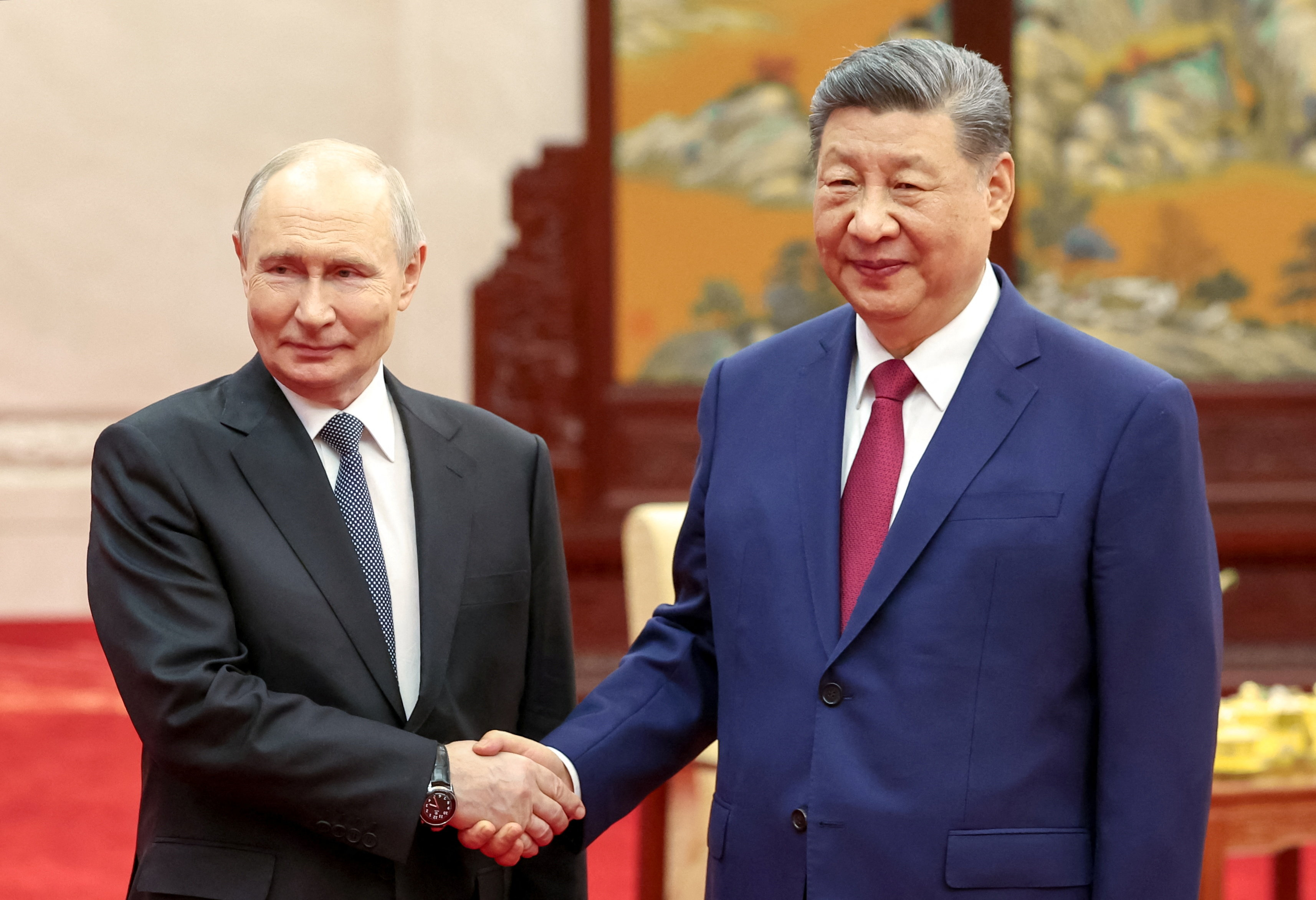 Russian President Vladimir Putin and Chinese President Xi Jinping shake hands as they pose for photos before a tea ceremony following their meeting at the Great Hall of the People in Beijing, China May 20, 2026. Sputnik/Alexander Kazakov/Pool via REUTERS ATTENTION EDITORS - THIS IMAGE WAS PROVIDED BY A THIRD PARTY.