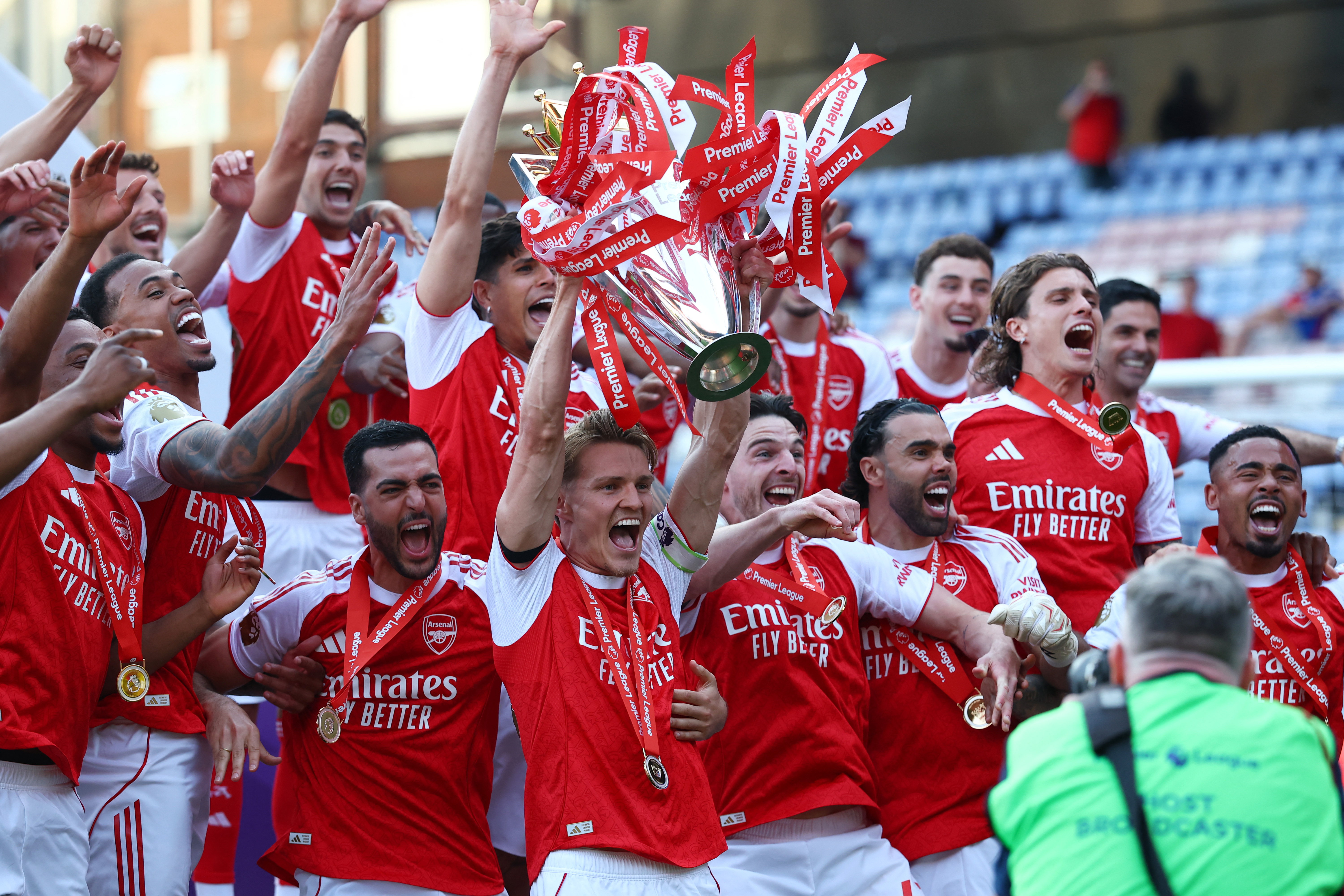 Arsenal's Martin Odegaard lifts the trophy as he celebrates with teammates.