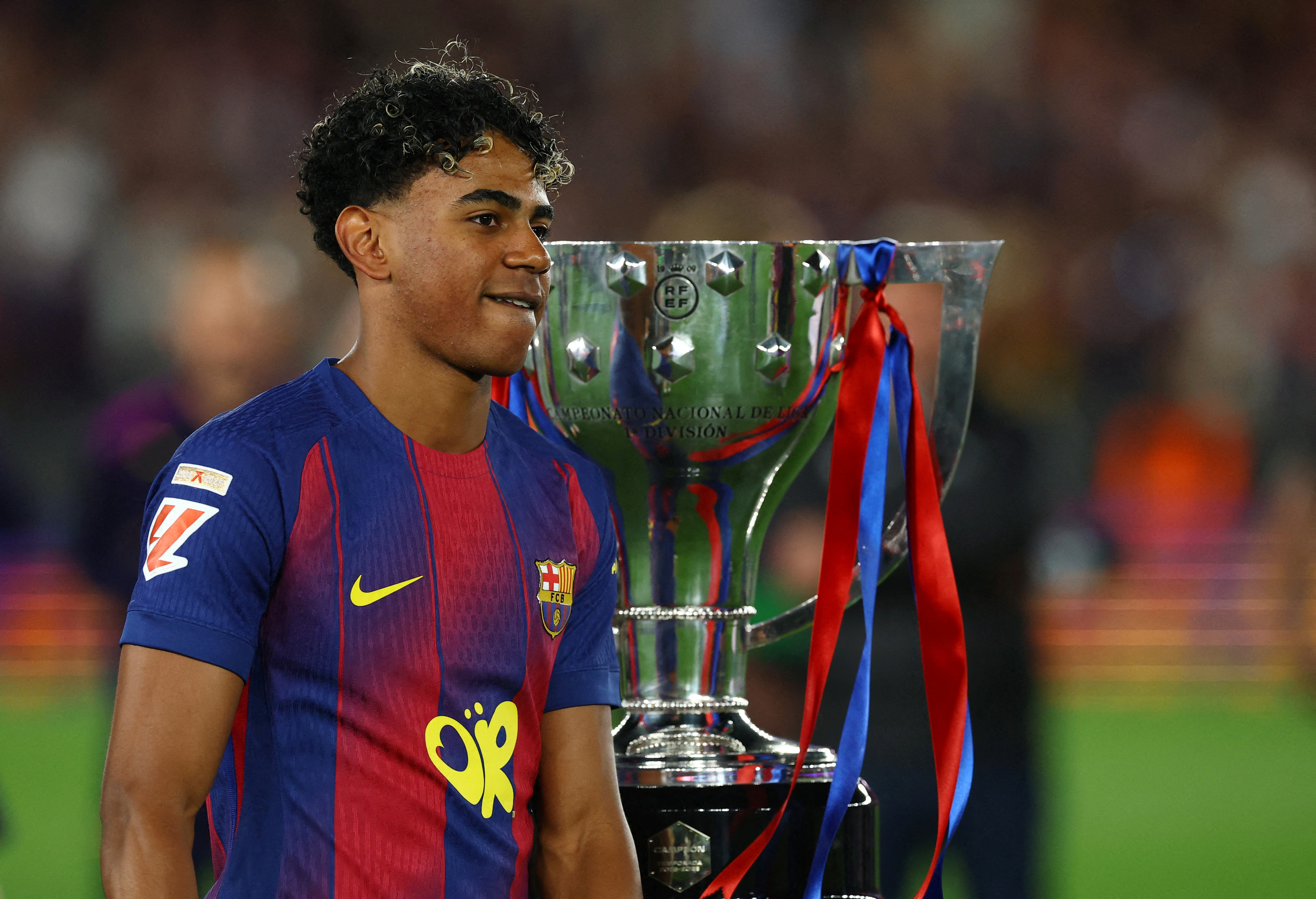 Barcelona's Lamine Yamal celebrates next to the trophy after winning the La Liga