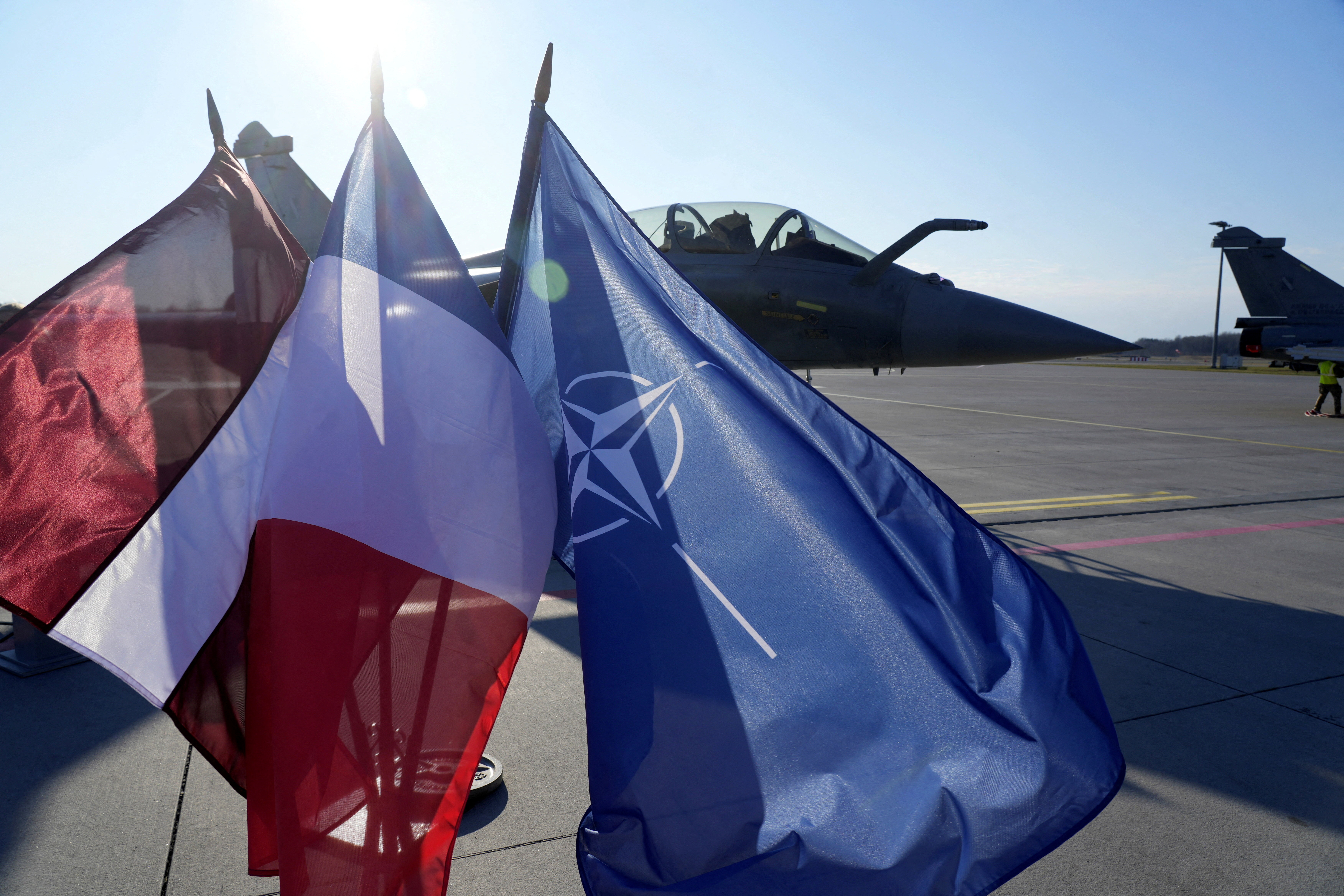 FILE PHOTO: Latvian, French and NATO flags flutter in front of a French Rafale fighter jet of the NATO Baltic Air Policing mission, in the Lielvarde air base, Latvia April 14, 2026. REUTERS/Ints Kalnins/File Photo