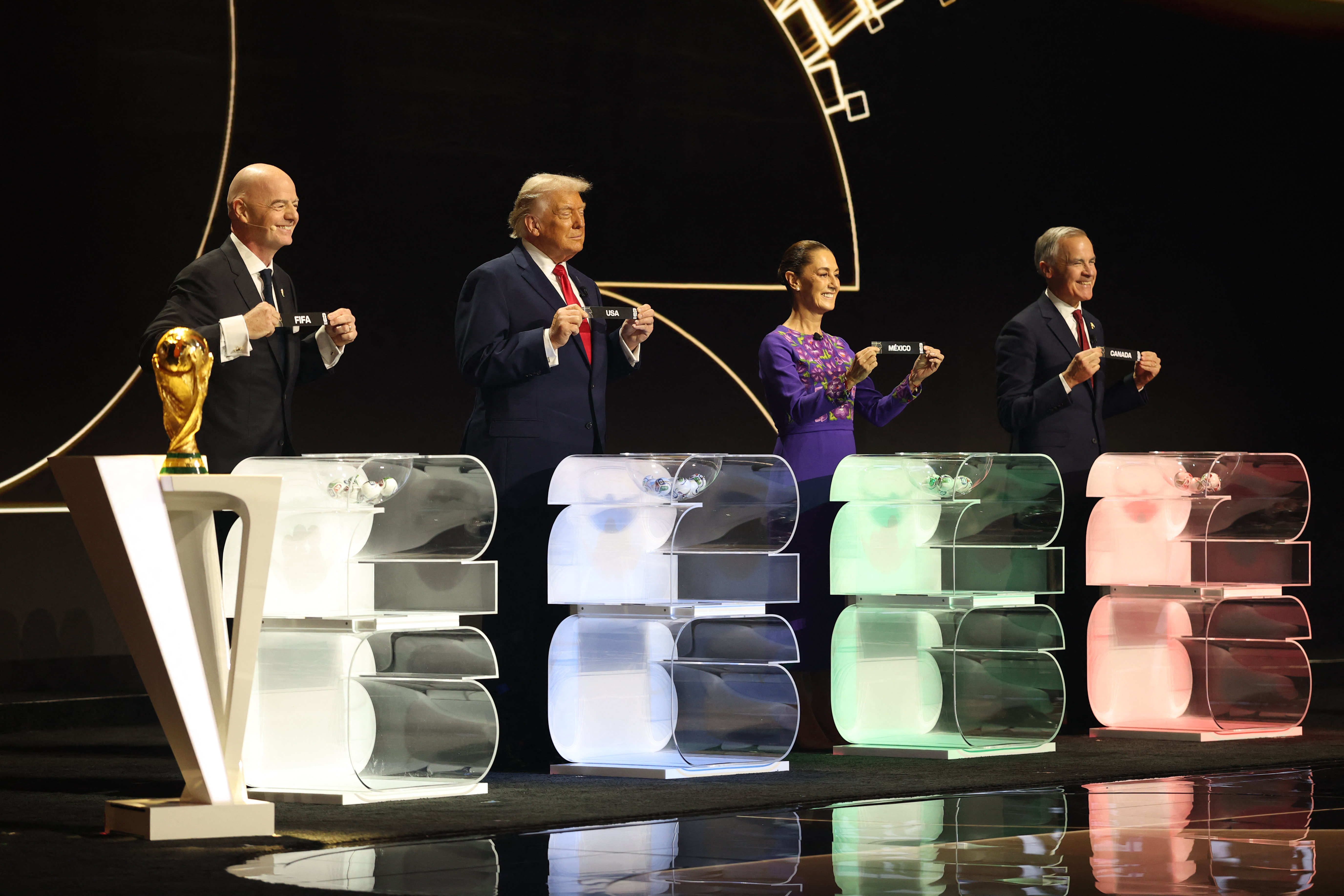 FIFA President Gianni Infantino, US President Donald Trump, Mexico's President Claudia Sheinbaum and Canada's Prime Minister Mark Carney pose with their cards during the draw for the 2026 FIFA Football World Cup.