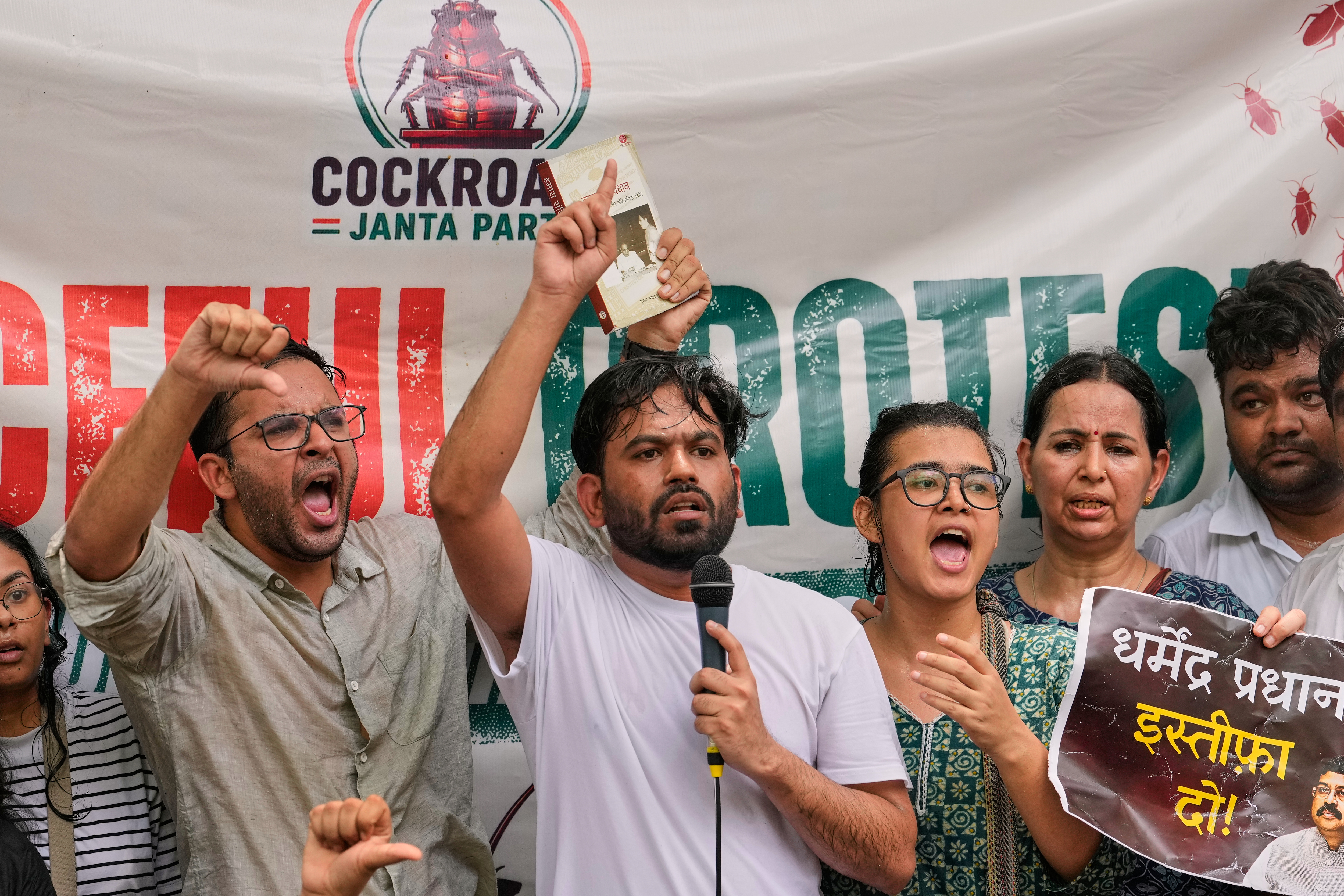 A man stands with a microphone at a protest