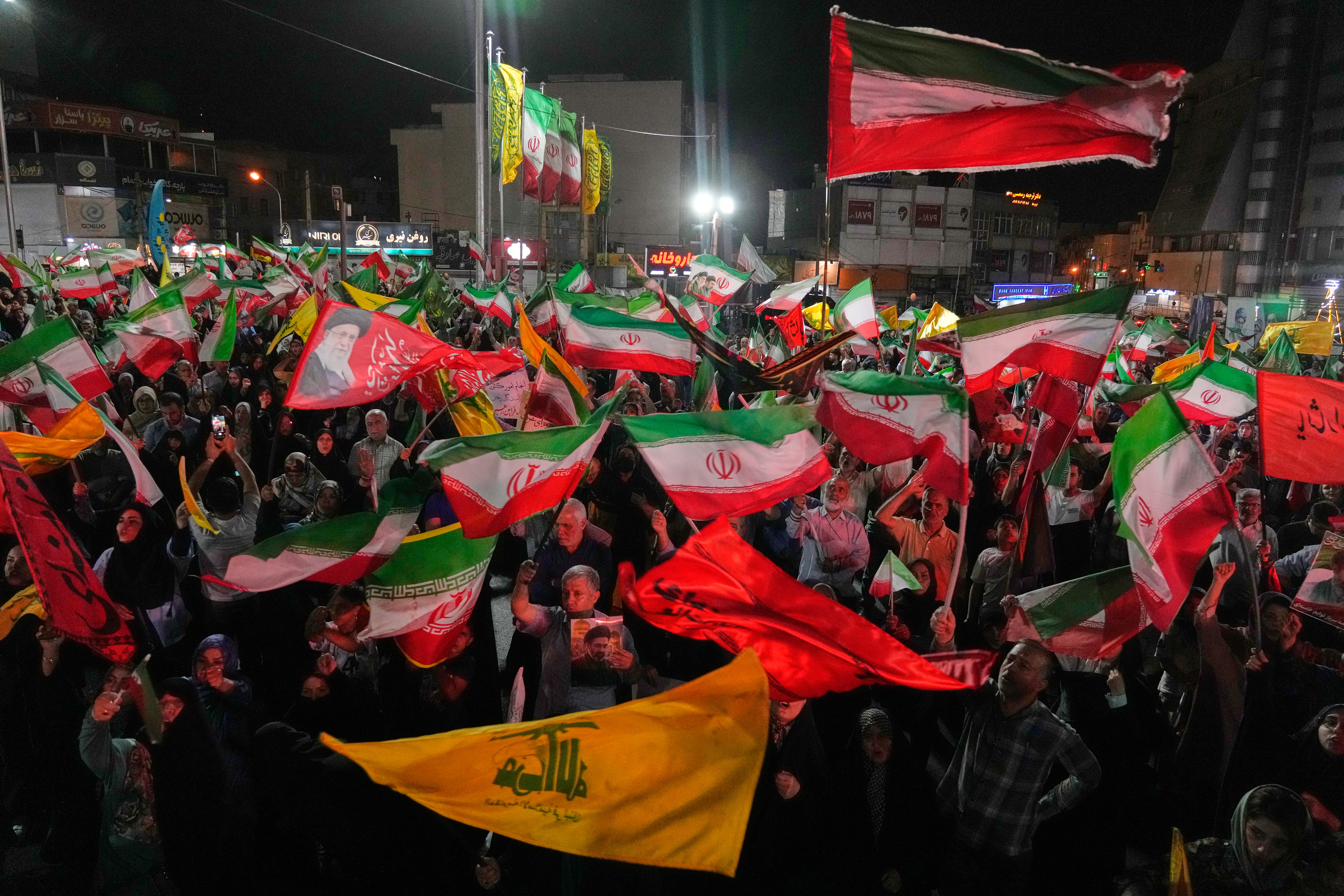 Pro-government Iranian demonstrators wave flags from Iran and Lebanon's Hezbollah in Tehran, Iran, Sunday, June 7, 2026. (AP Photo/Vahid Salemi)