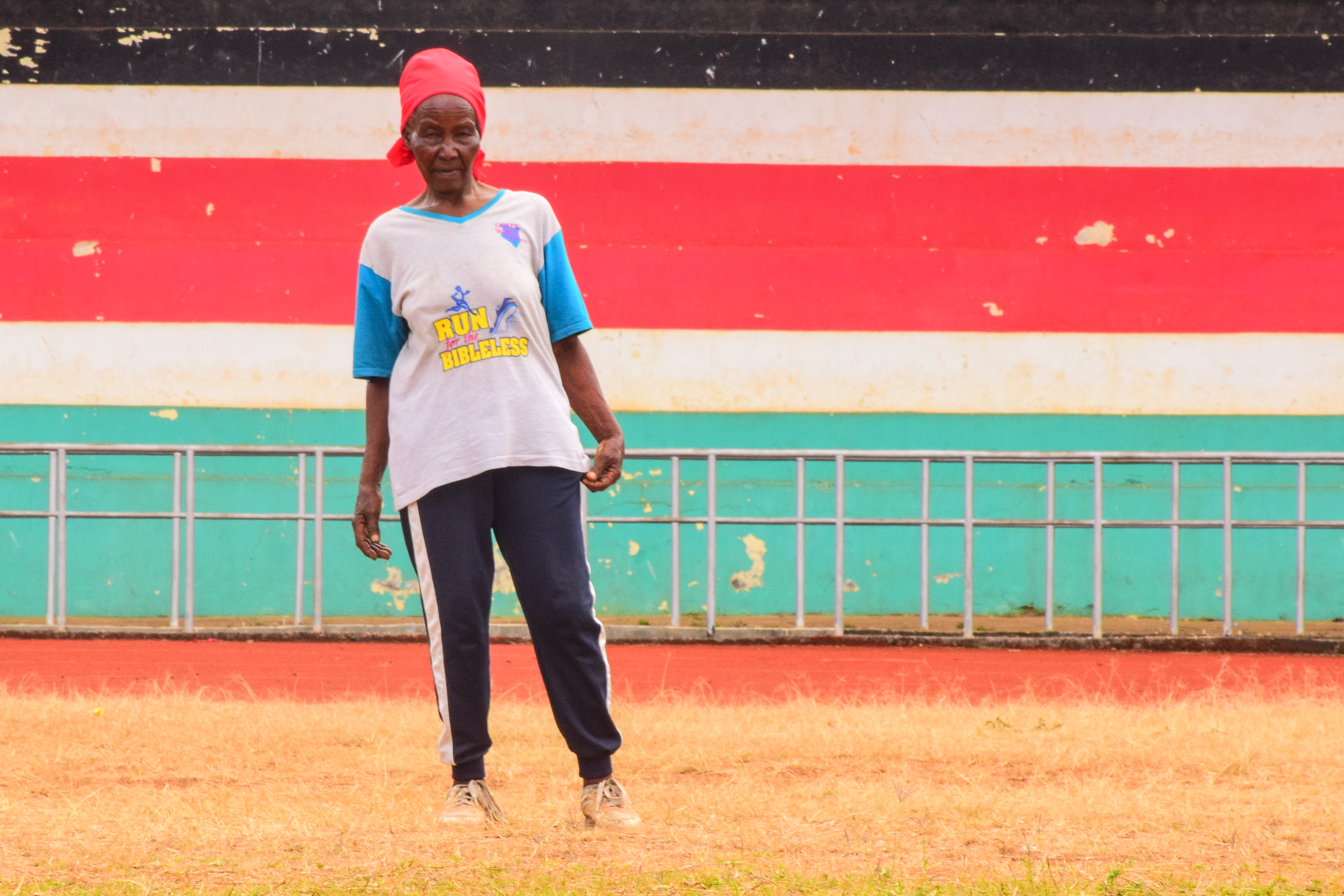 An 82-year-old runner warms up on a red-earthed road in Meru County, where older athletes train three times a week to stay fit and independent.