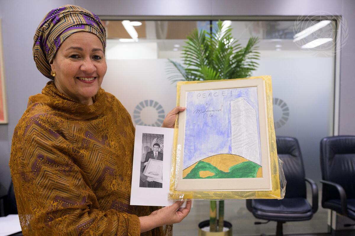 Amina Mohammed holding Muhammad Ali's painting